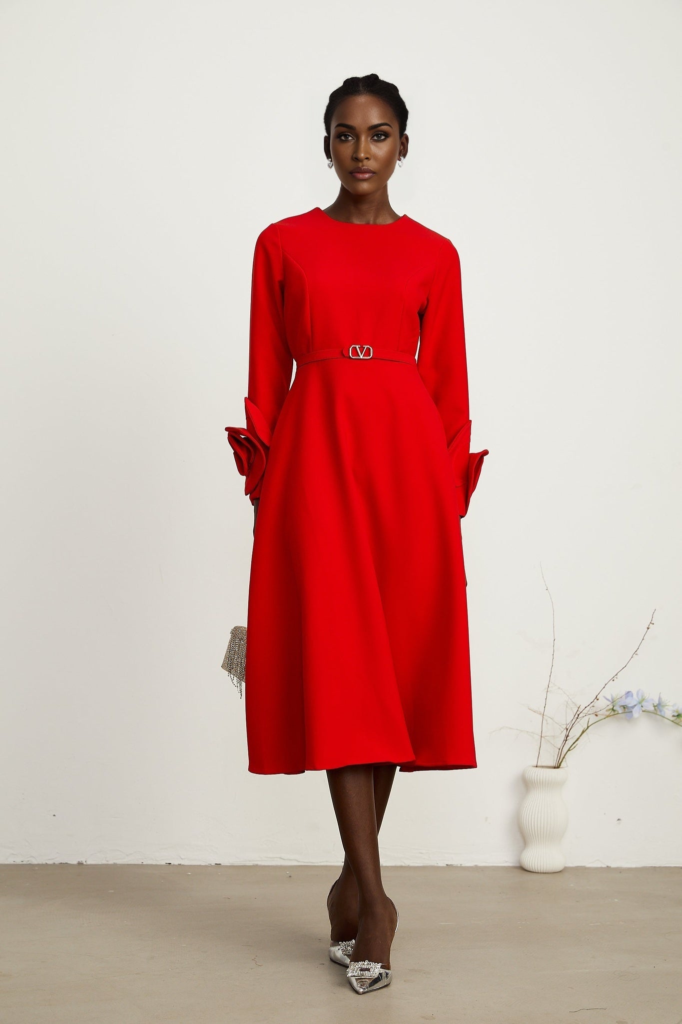 Woman wearing a red long sleeve dress with floral embellishments by Aurelia