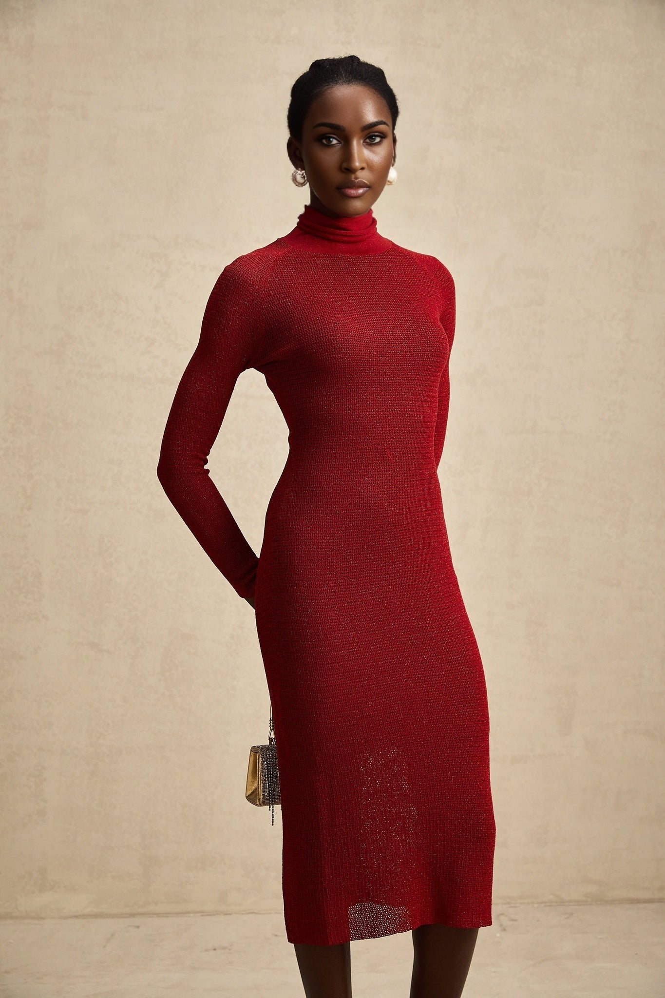 Woman wearing a red metallic midi dress with pointelle knit pattern standing in a relaxed pose