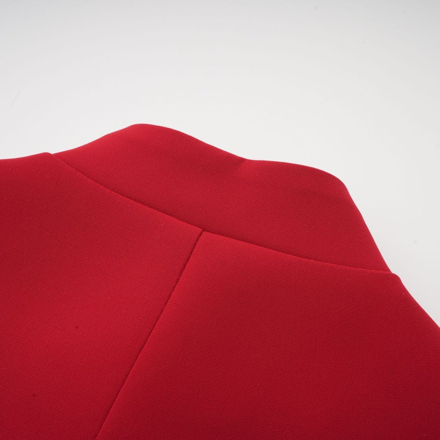 Woman wearing a red pleated blouse and matching skirt set called Colette The outfit features a loose fitting top with long sleeves and a flowy pleated skirt that falls below the knee