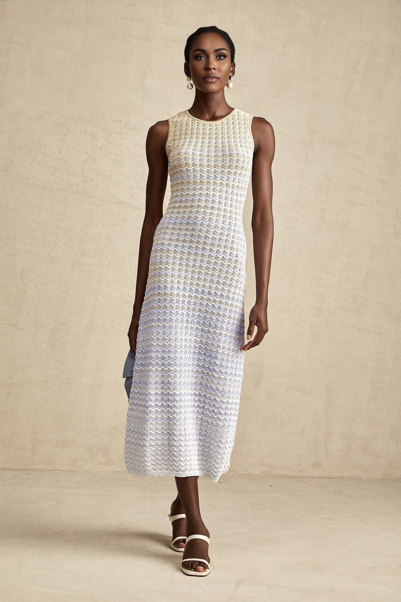 Woman wearing a ribbed knit midi dress with contrasting color details and a formfitting silhouette