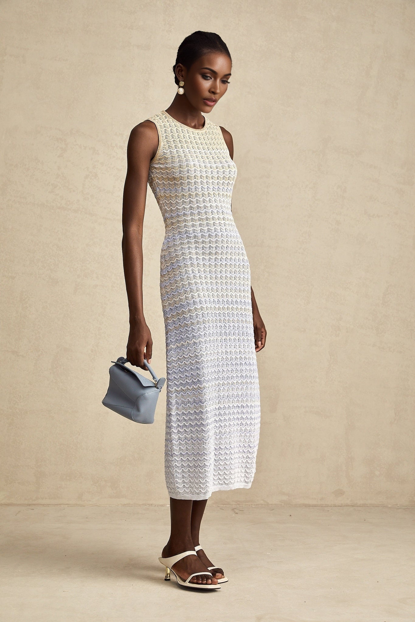 Woman wearing a ribbed knit midi dress with contrasting color details featuring a fitted silhouette and long sleeves