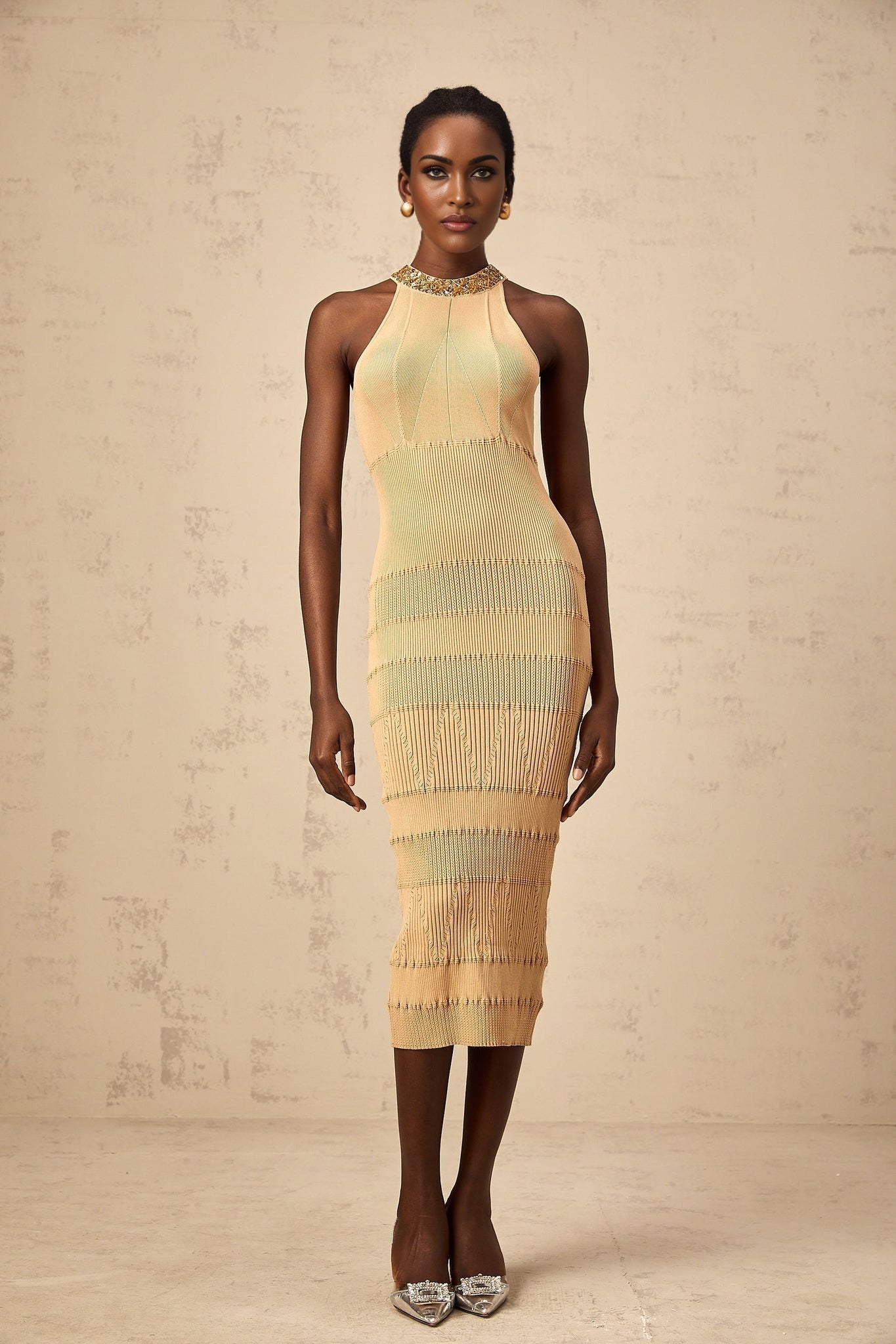 Woman wearing a shimmering long sleeve midi dress with ribbed texture and sequin embellishments