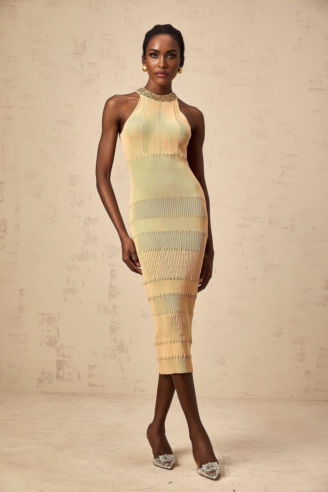 Woman wearing a shimmering sequined midi dress with ribbed texture in a fitted silhouette