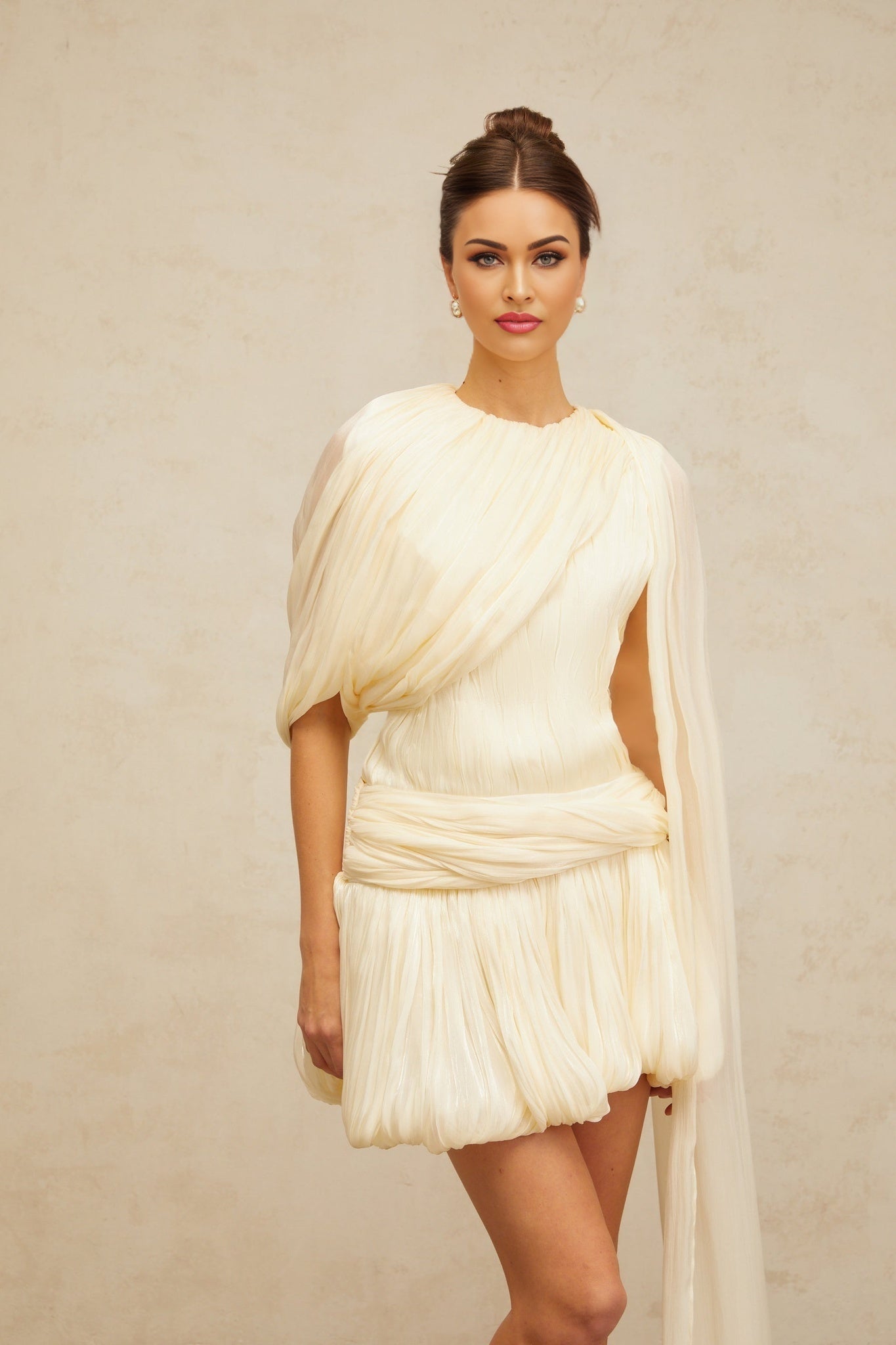 Woman wearing a short pleated dress with ribbon accents
