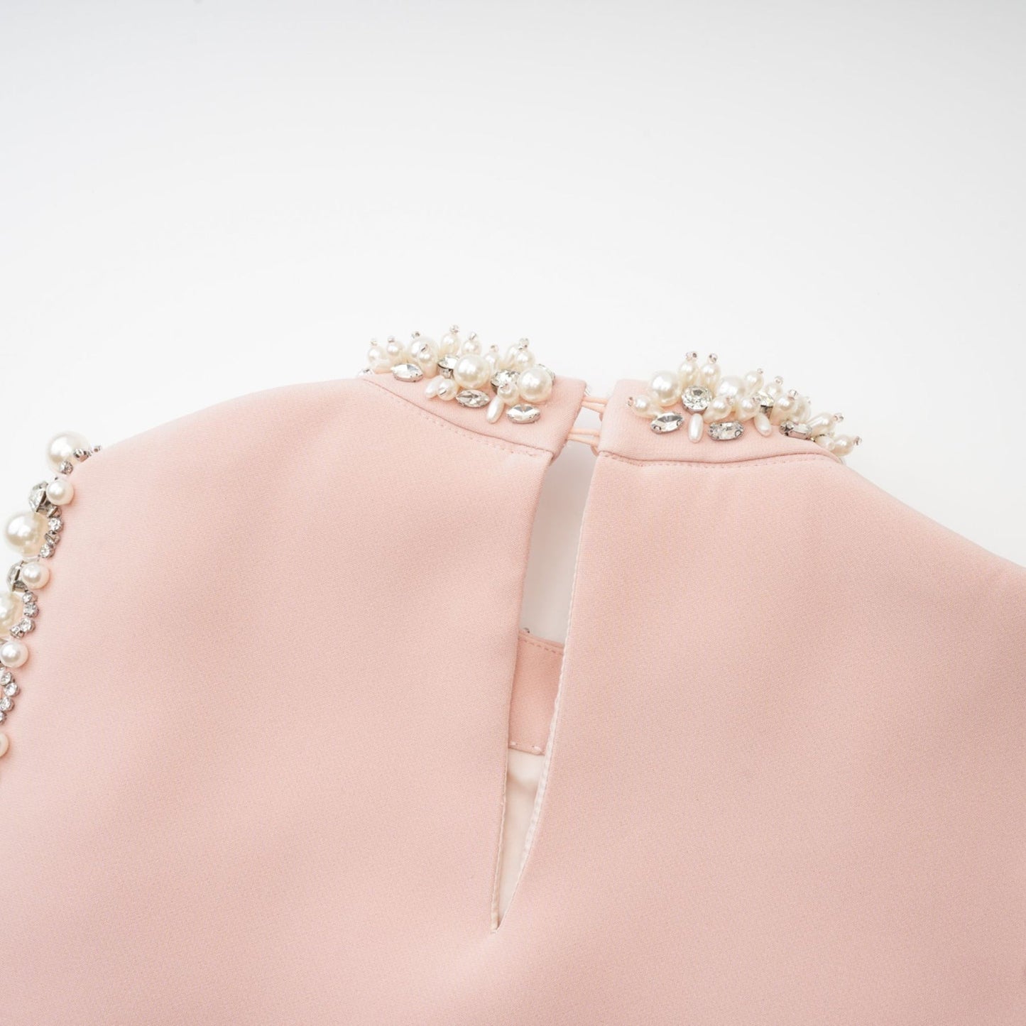 Pink sleeveless dress with crystal embellishments faux pearls and a round neck thighlength secured with rear button fastening Composed of 80% Polyester and 20% Cotton
