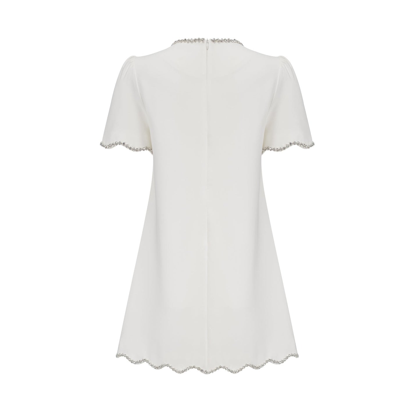 Woman wearing a short white dress with crystal embellishments