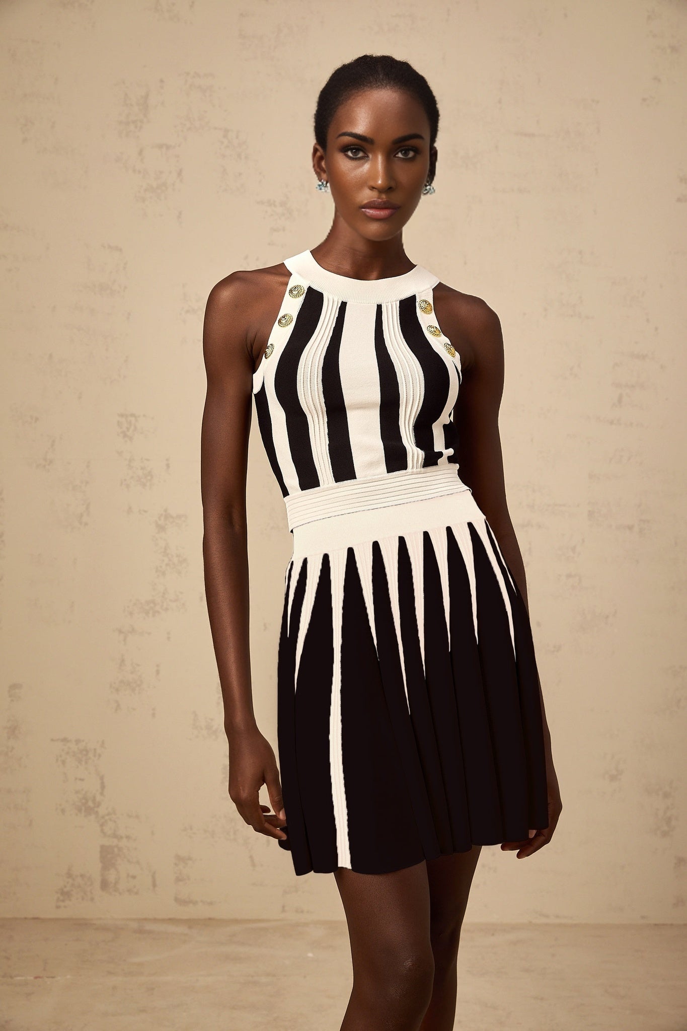 Woman wearing a striped knit top and matching skirt set in contrasting colors named Iseult