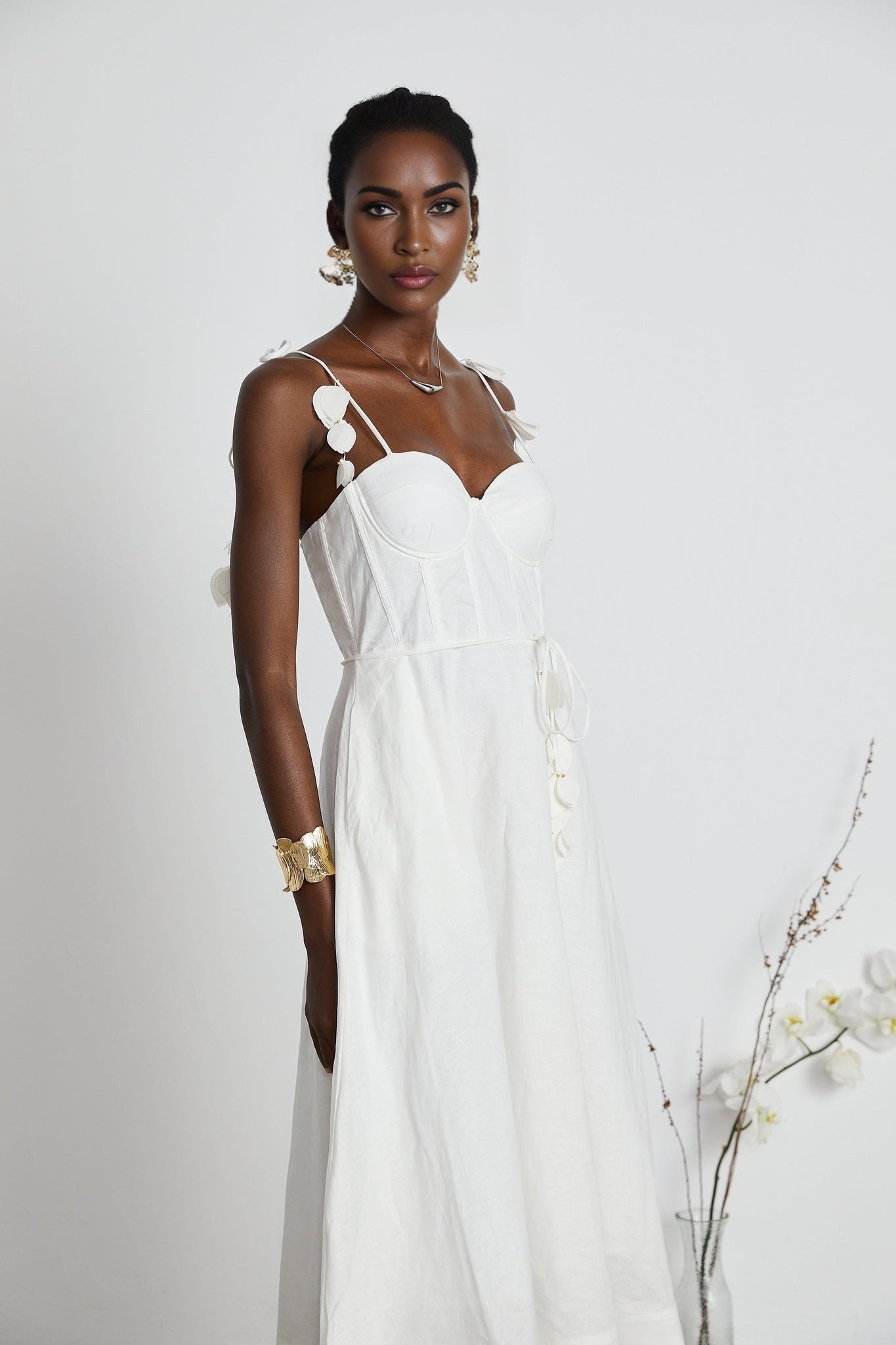 Woman wearing a white corset style midi dress with fitted bodice and flared skirt