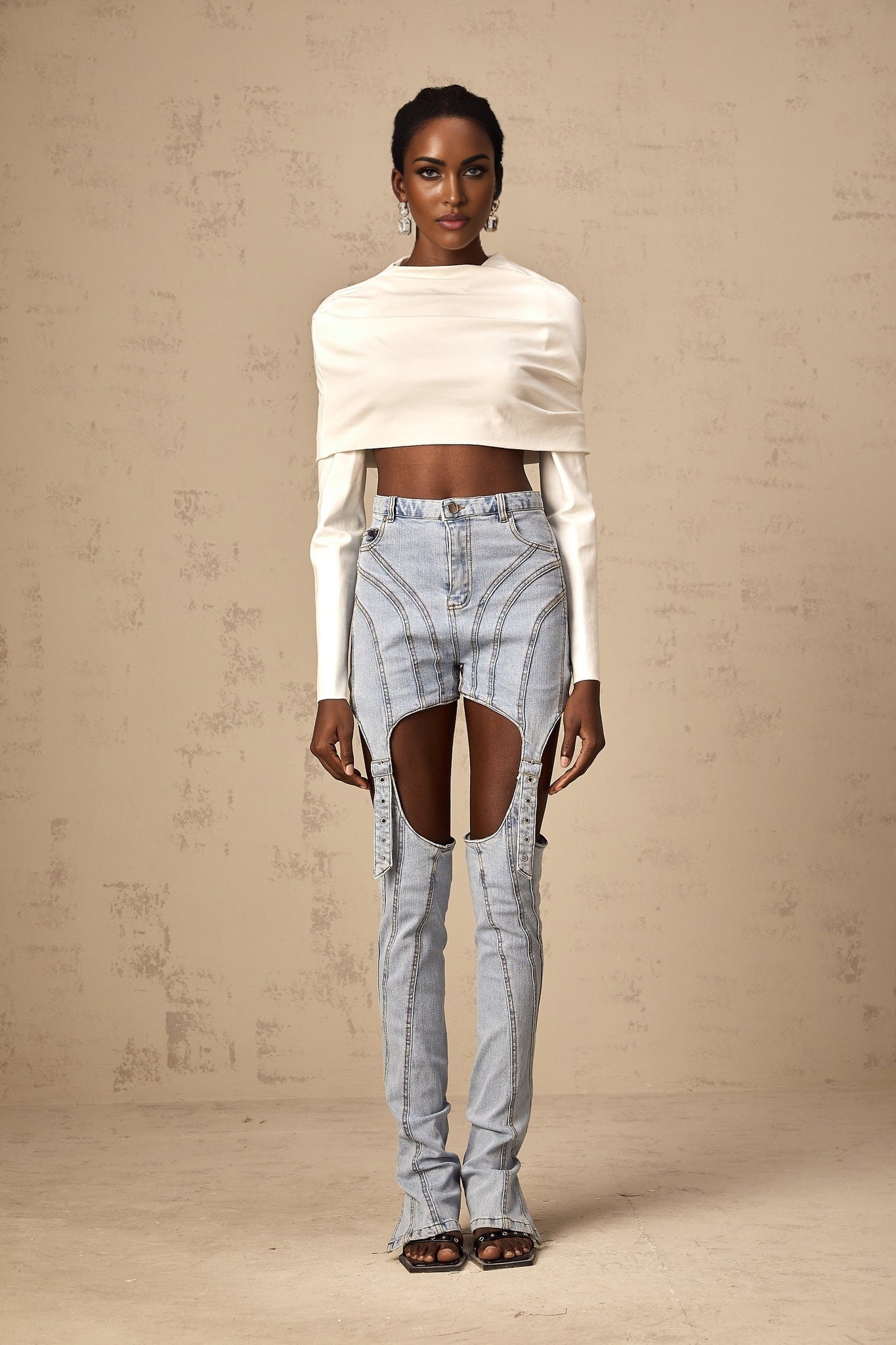 Woman wearing a white cropped sleeveless top with ruched detailing on the front