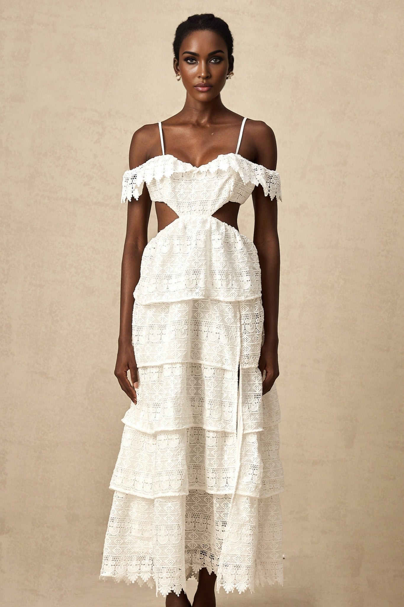 Woman wearing a white lace midi dress with openwork pattern standing in a neutral background