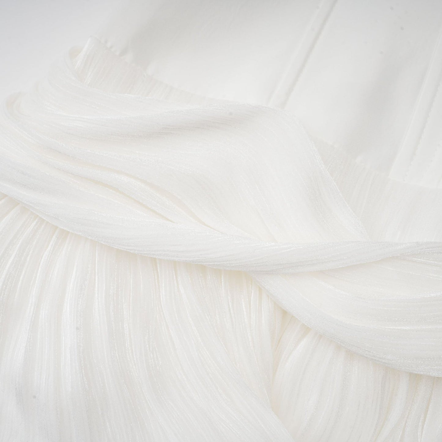 Woman wearing a white mini dress with pleats and cinched waist