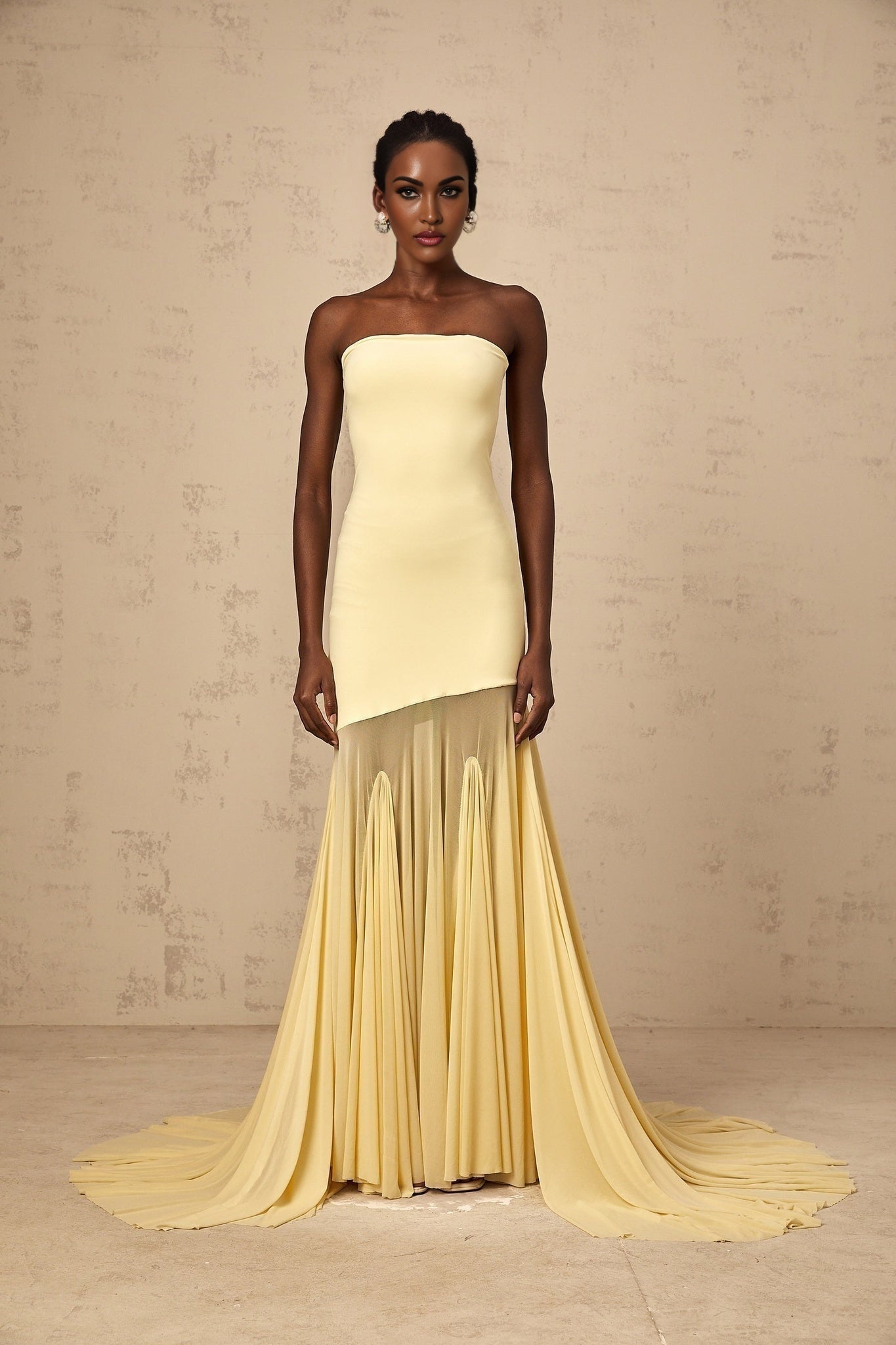 Woman wearing a yellow off shoulder maxi dress with sheer tulle fabric standing in a relaxed pose