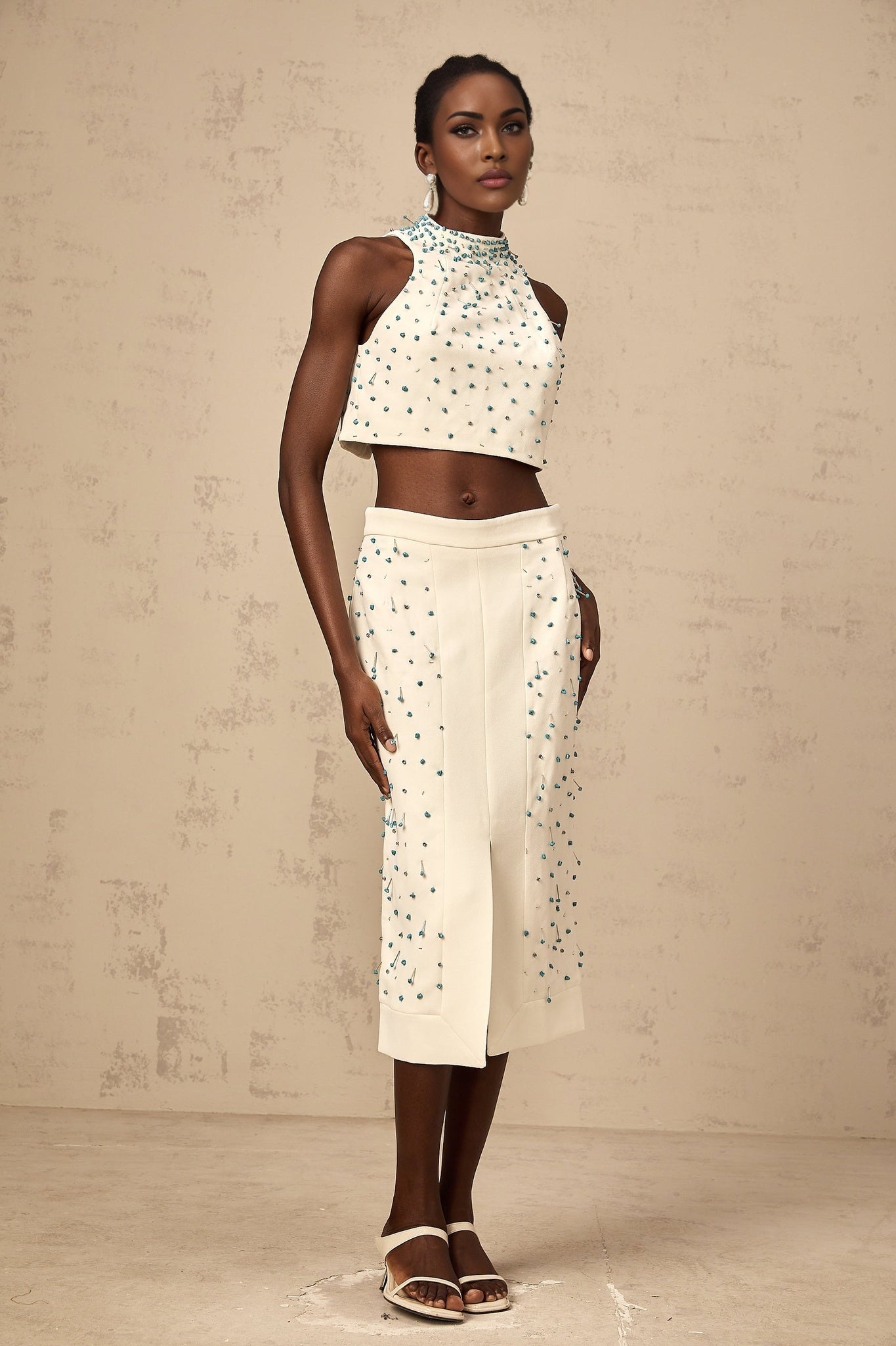 Woman wearing an offwhite matching set with embellished top and skirt named Clothilde
