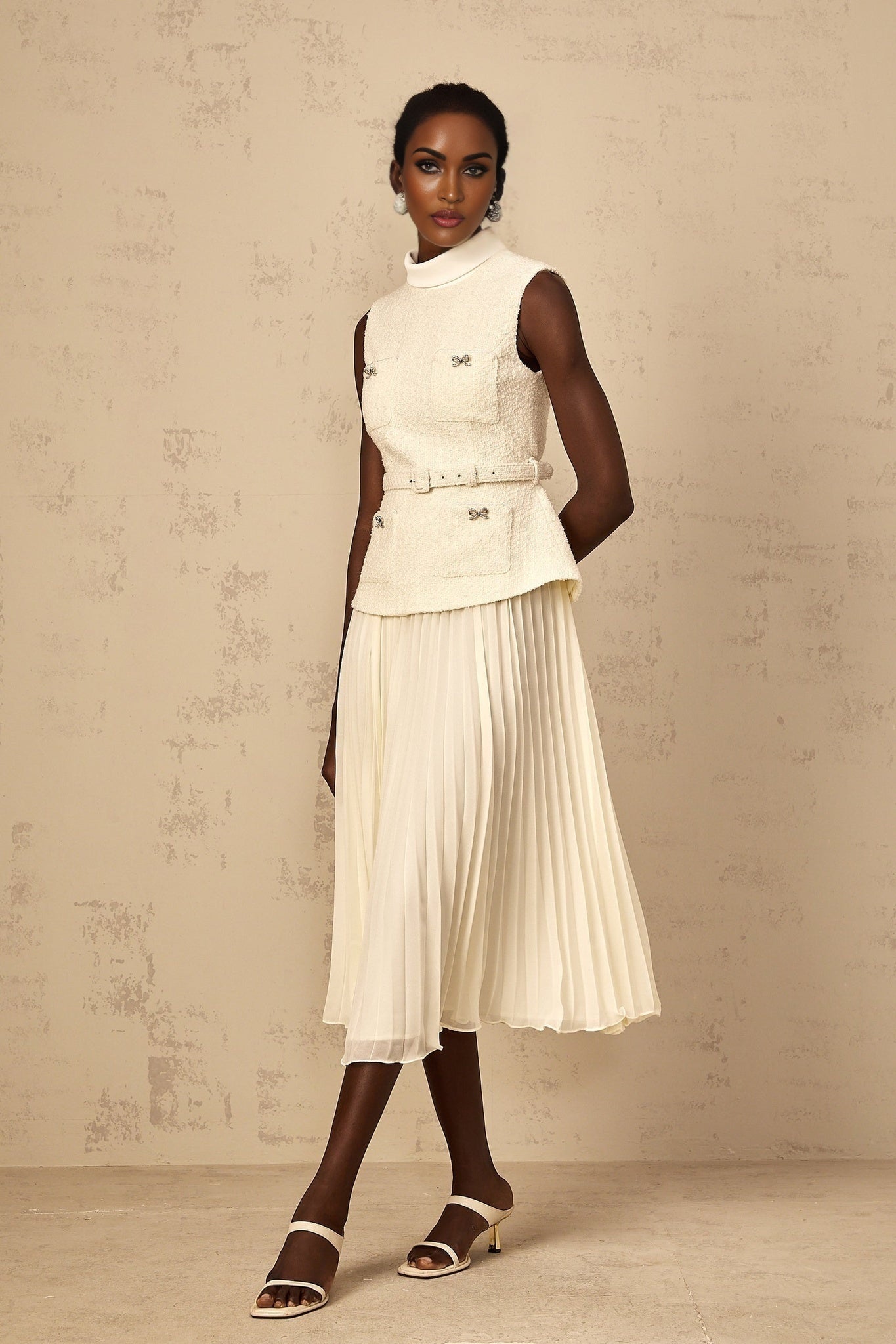 Woman wearing an offwhite midi dress with tweed fabric and tulle panel details