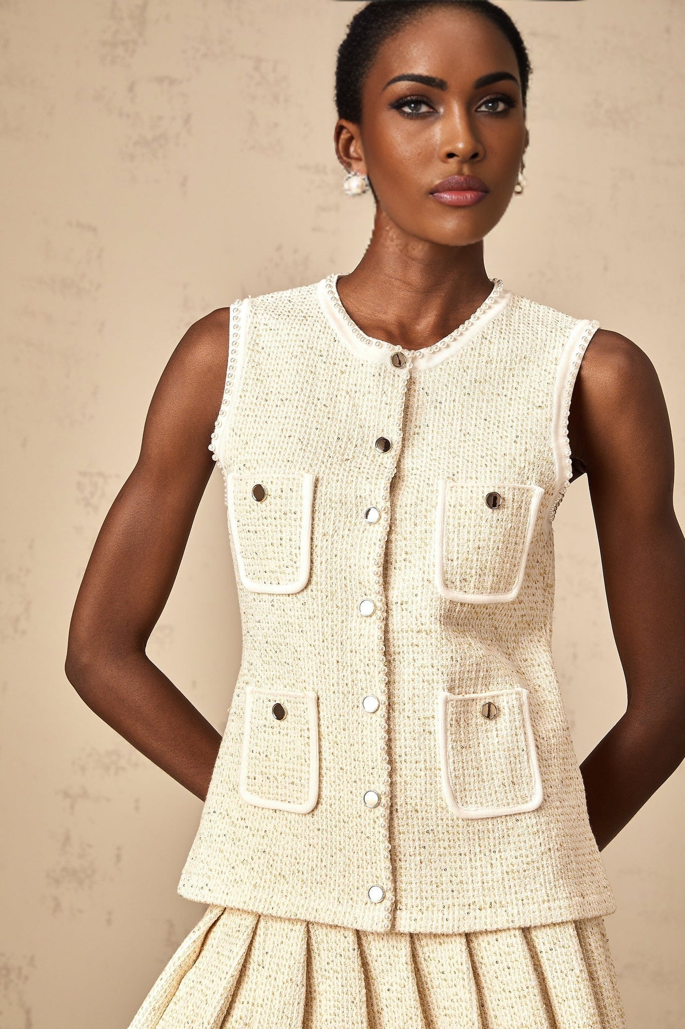Woman wearing beige knit vest top and matching skirt adorned with sequins Hélène two piece set