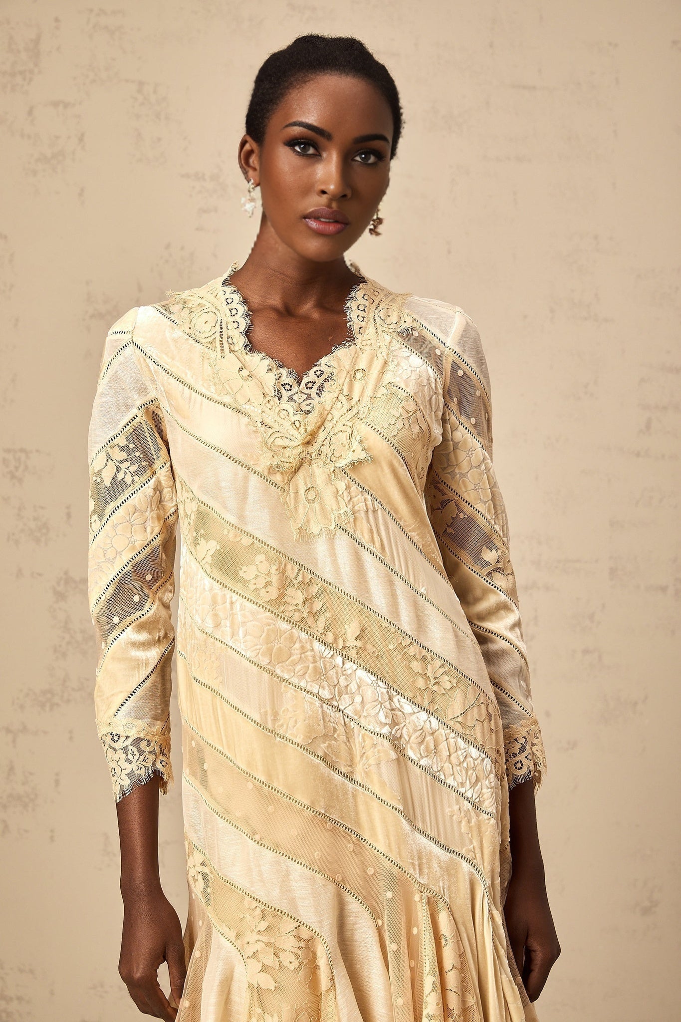 Woman wearing beige midi dress with diagonal stripes and panel detailing