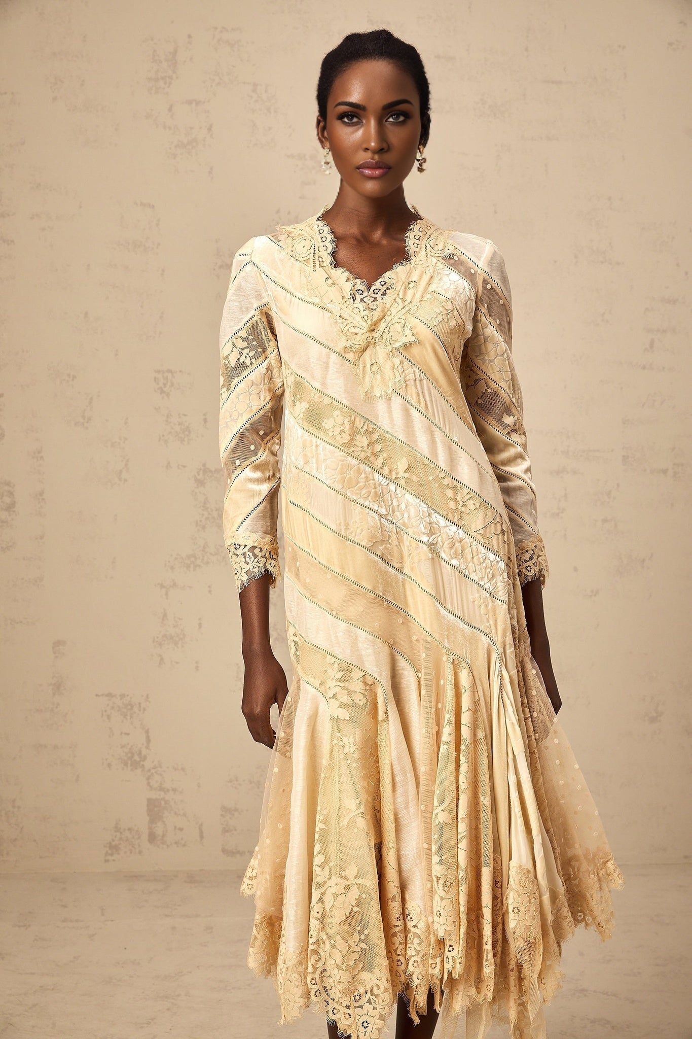 Woman wearing beige midi dress with diagonal stripes and panel details