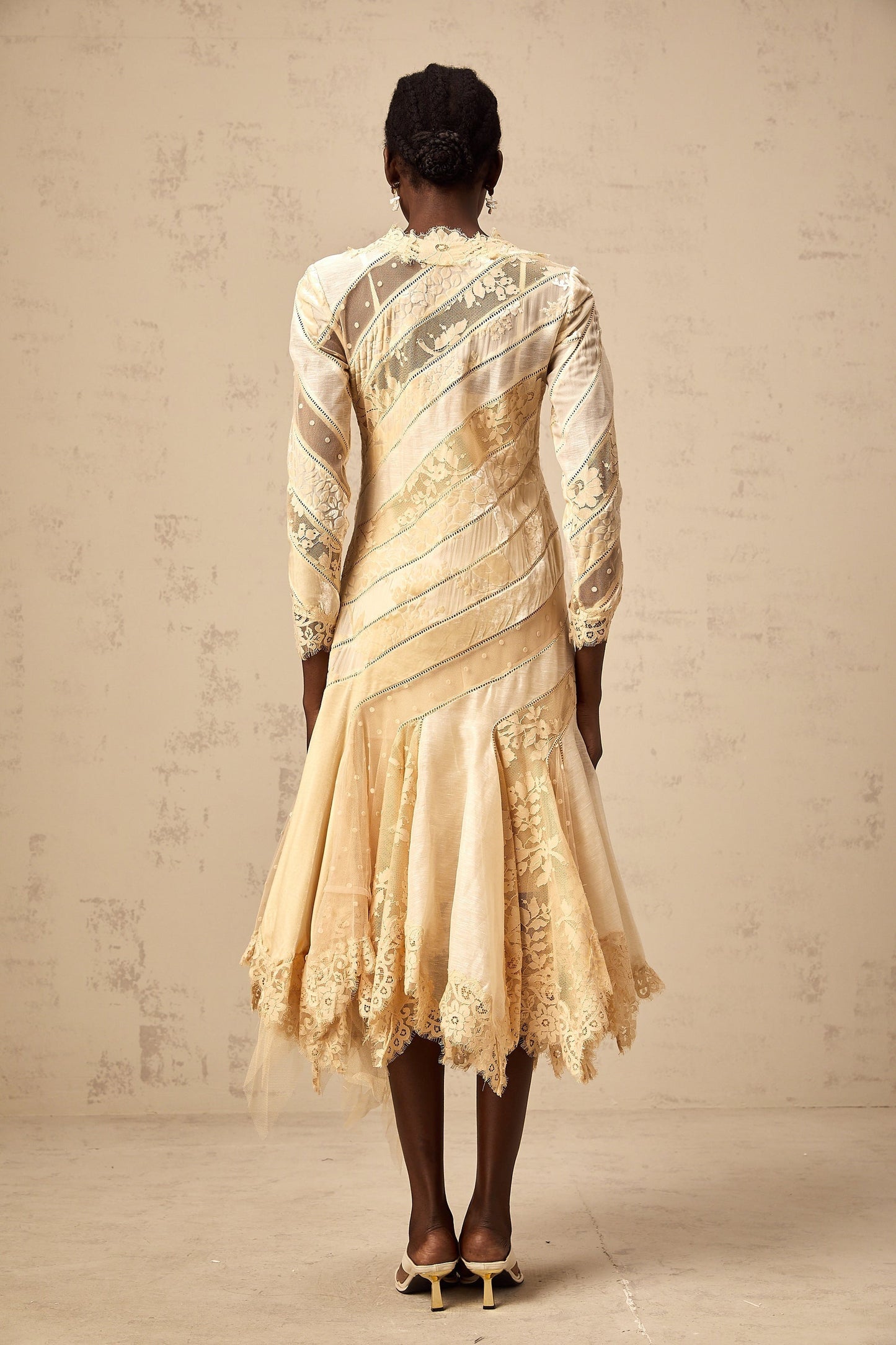 Woman wearing beige midi dress with diagonal stripes and panel details
