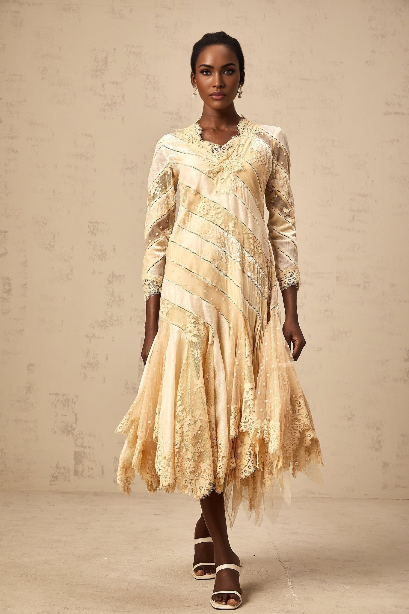 Woman wearing beige midi dress with diagonal stripes and panelled design