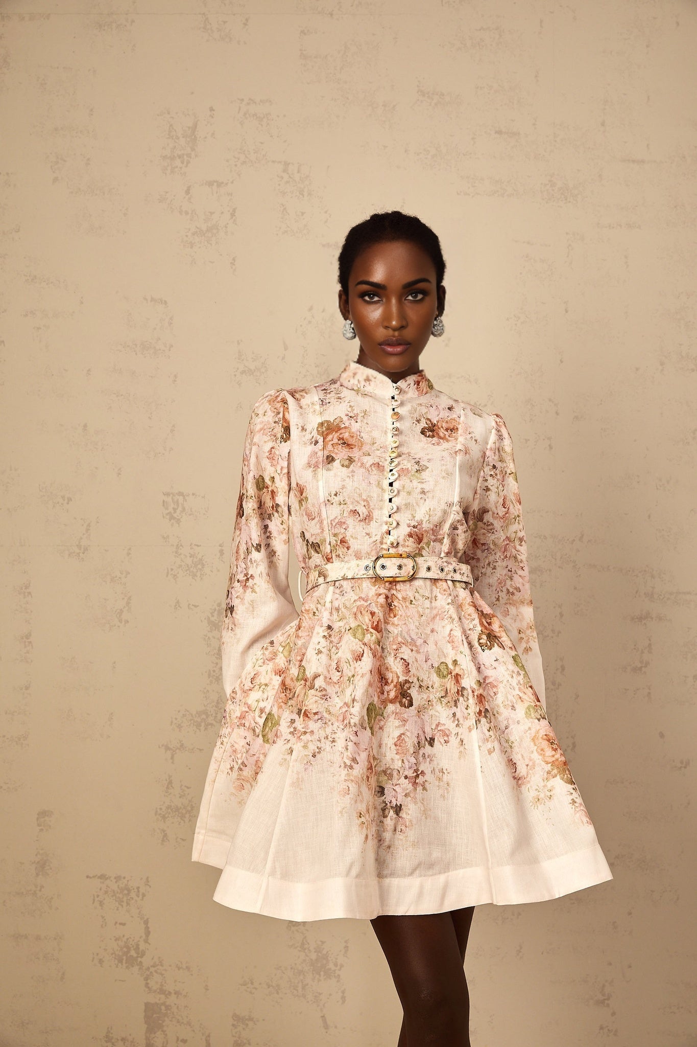 Woman wearing beige mini dress with floral print pattern short sleeves and flowy skirt
