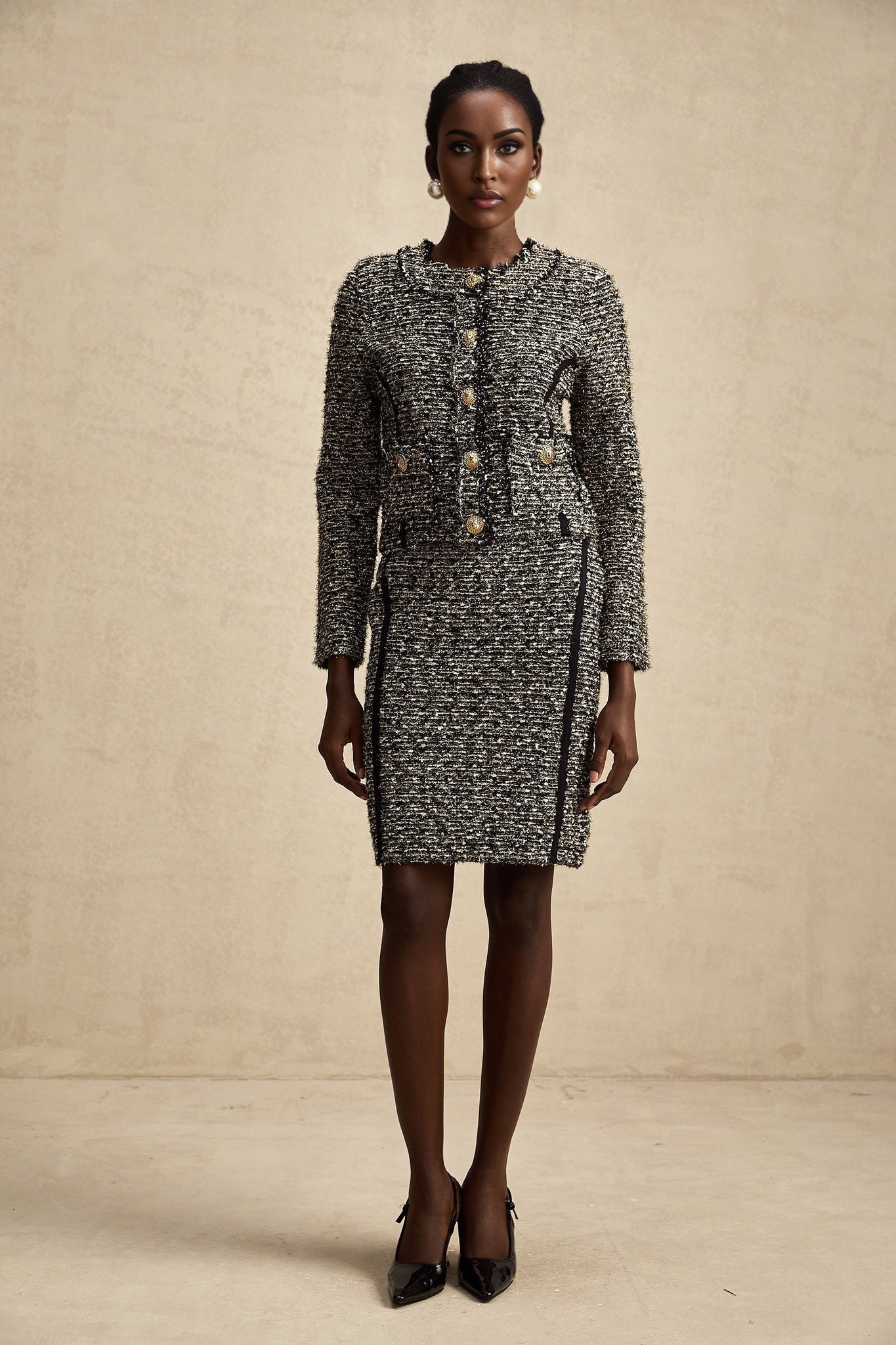 Woman wearing black and gold lurex jacket with matching skirt elegant evening outfit set