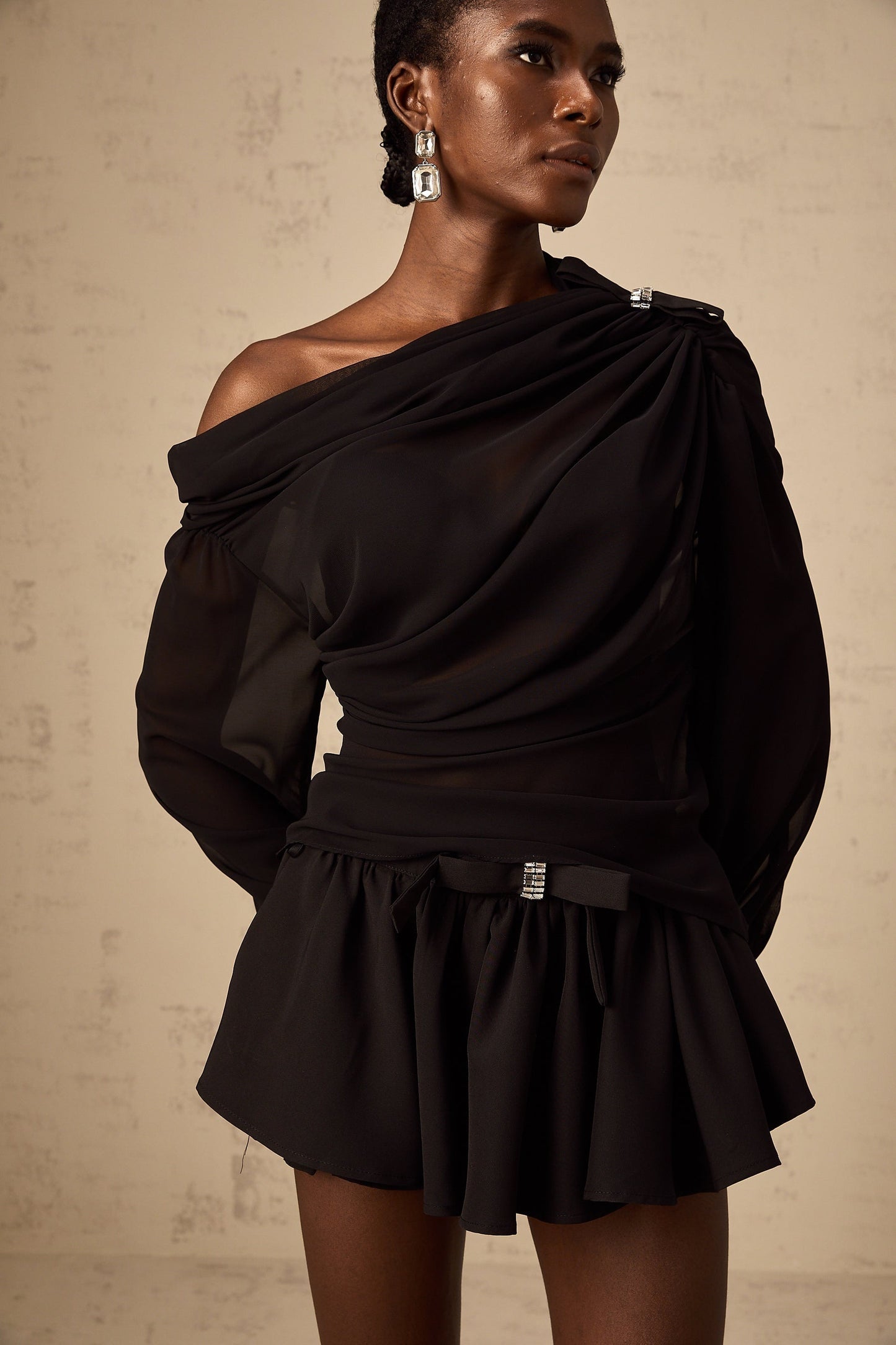 Woman wearing black asymmetric tulle blouse and matching skirt set Andrea style