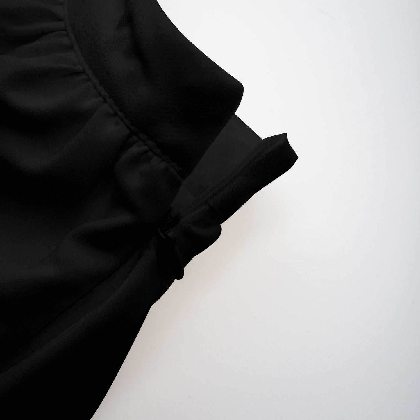 Woman wearing black asymmetric tulle blouse and matching skirt set named Andrea