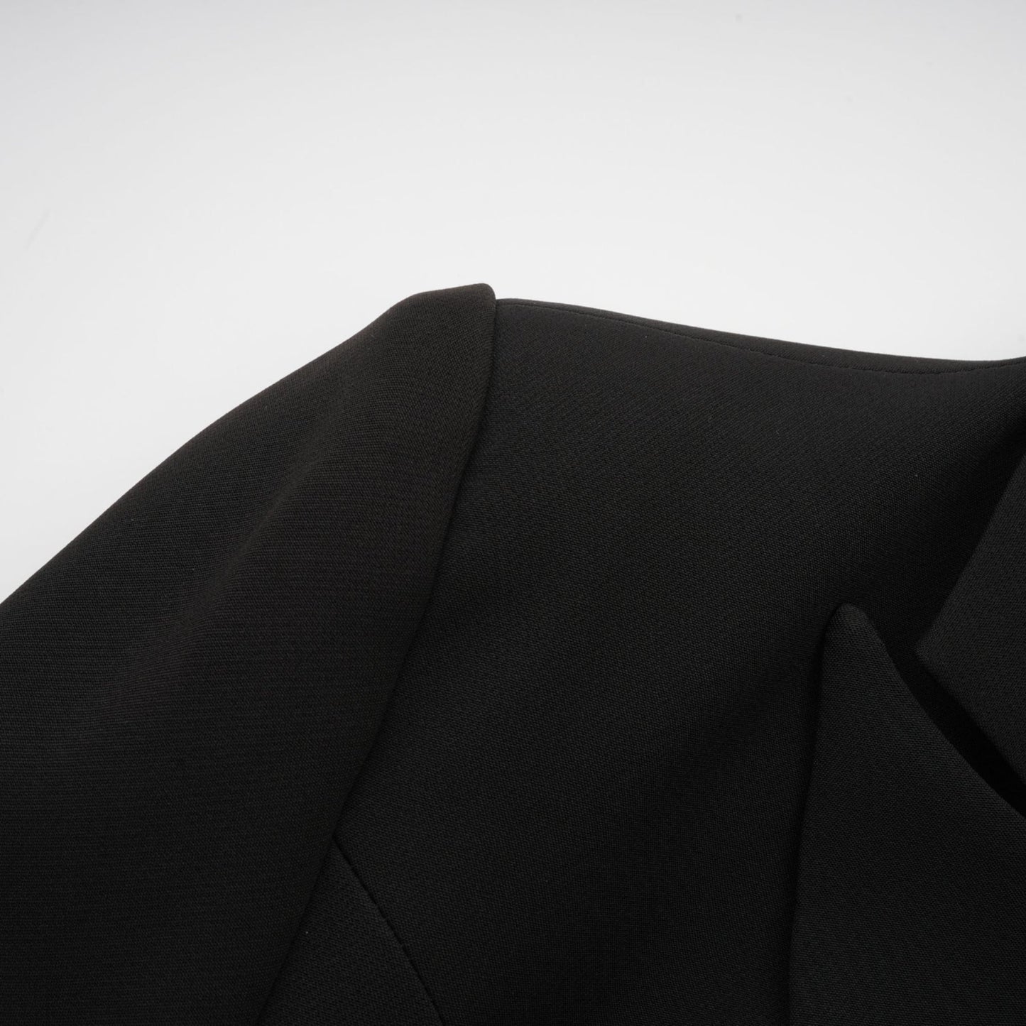 Woman wearing black blazer with bowknot detail and cutout design