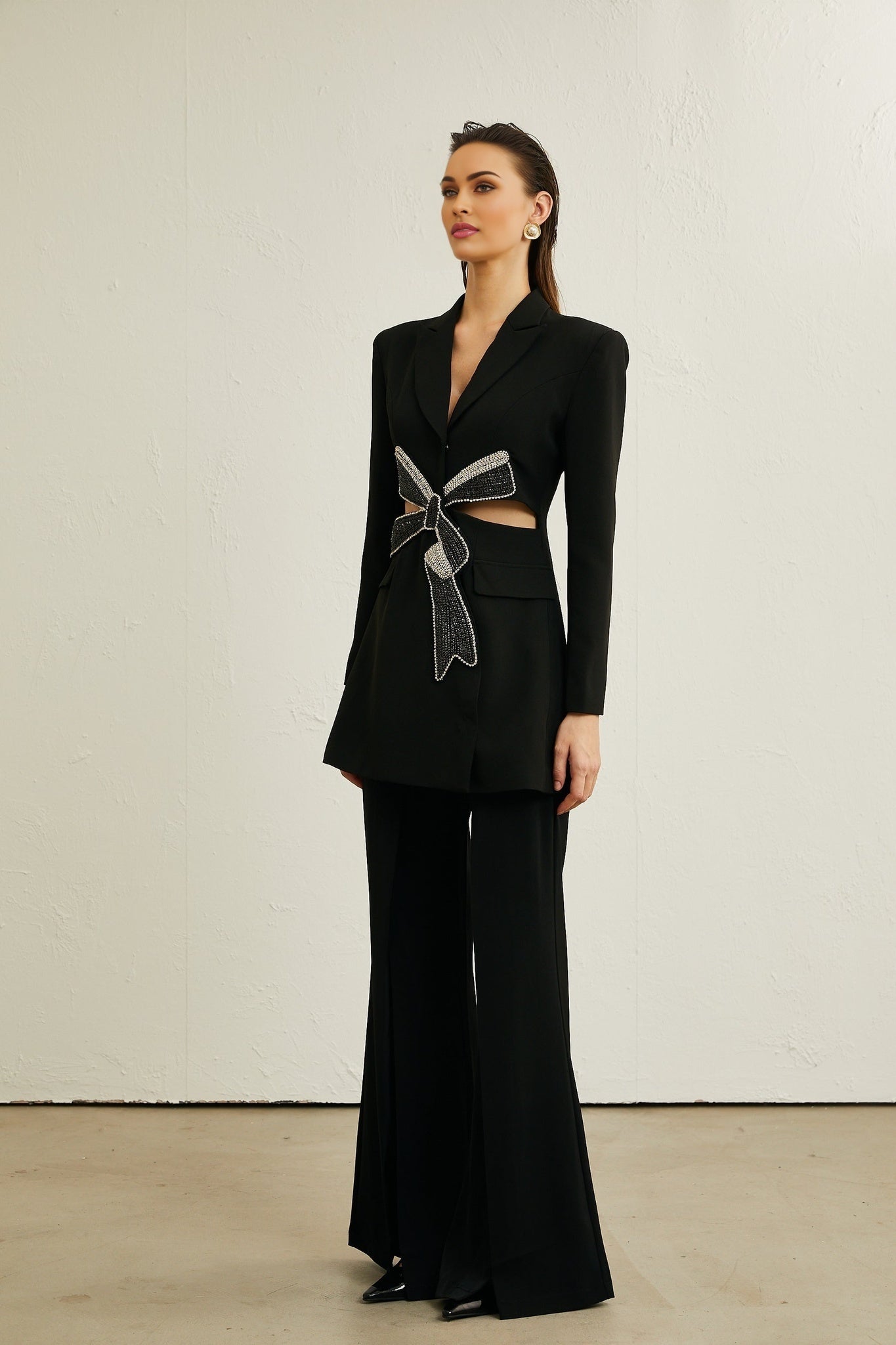 Woman wearing black blazer with bowknot detail and cutout design