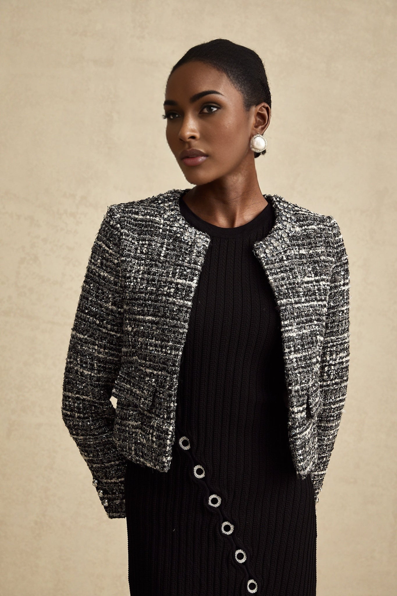Woman wearing black bouclé tweed jacket with textured fabric and classic design