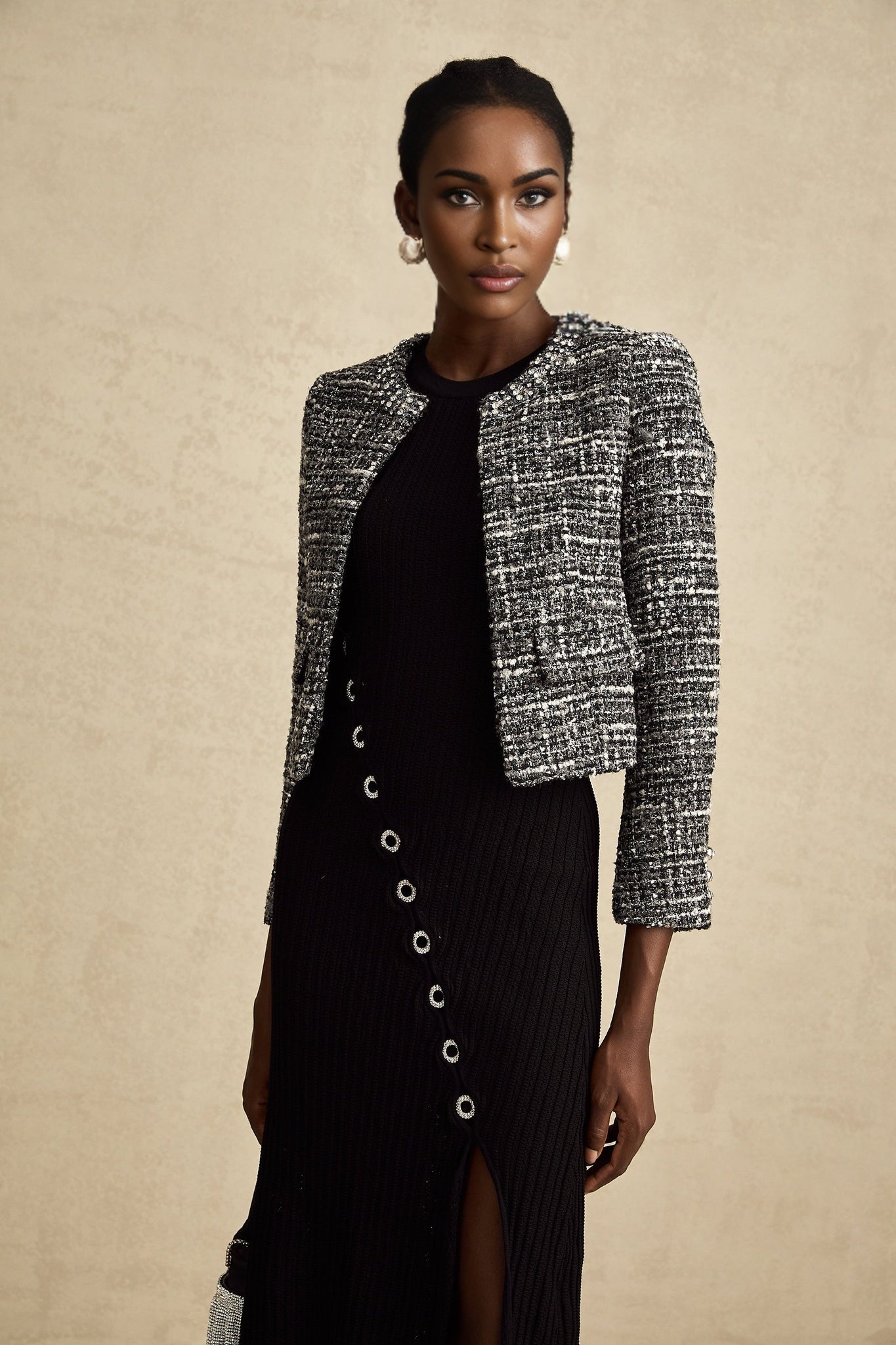 Woman wearing black bouclé tweed jacket with textured fabric and tailored fit