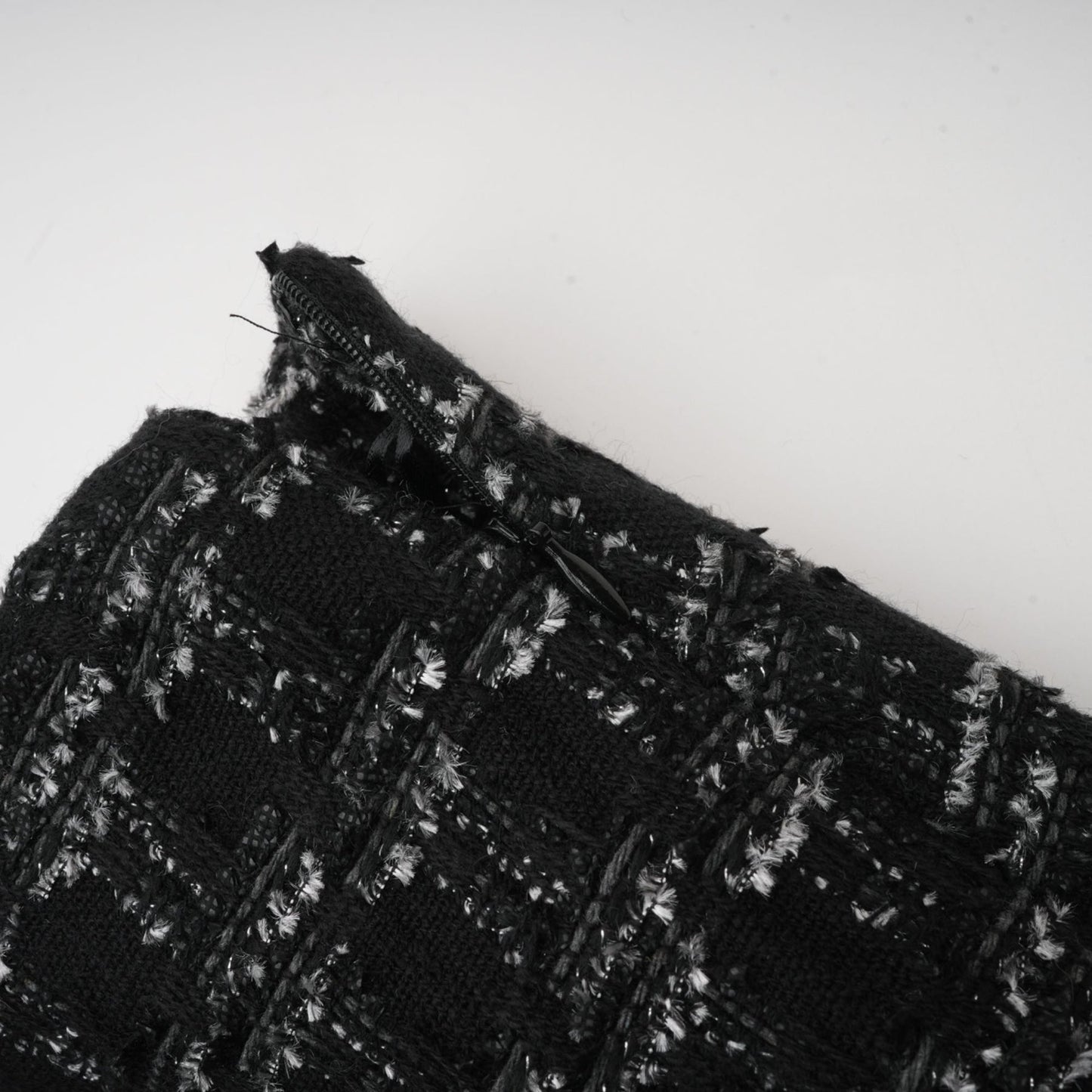 Woman wearing black checked tweed vest top and matching skirt set called Axelle