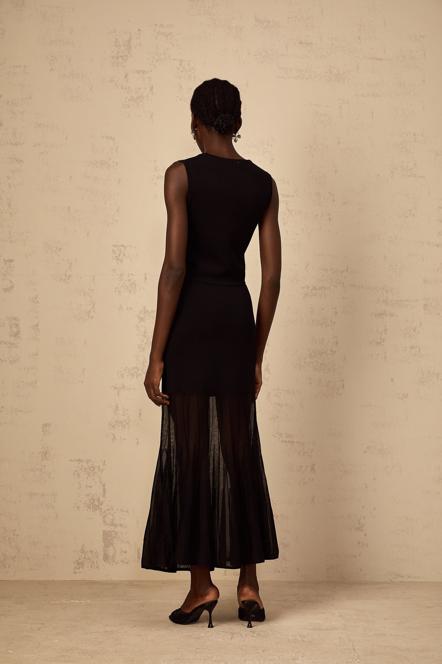 Woman wearing black fine knit matching set with panelled design top and bottoms