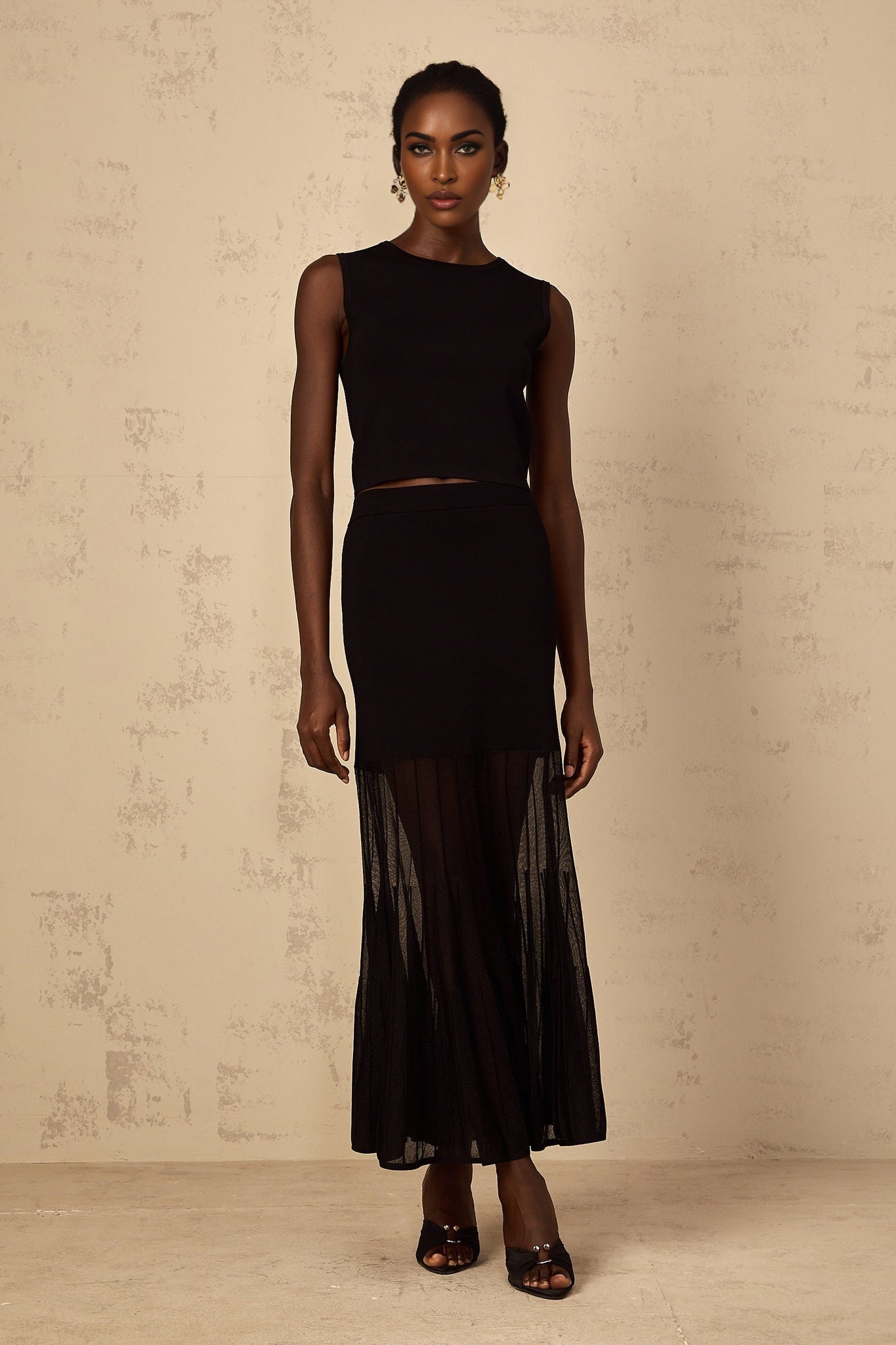 Woman wearing black fine knit matching set with panelled design top and bottoms