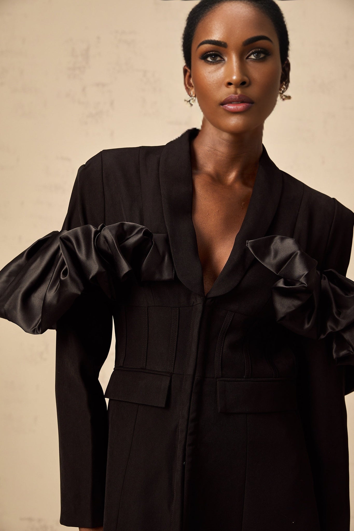 Woman wearing black fitted blazer with panelled design and boned structure