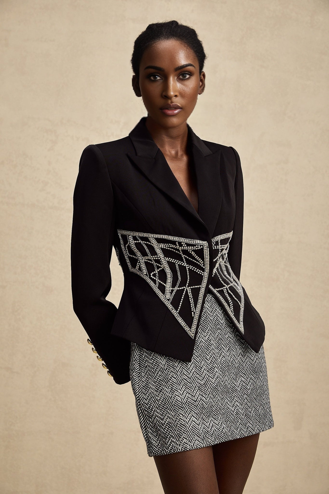 Woman wearing black jacket with embellished details and cinched waist