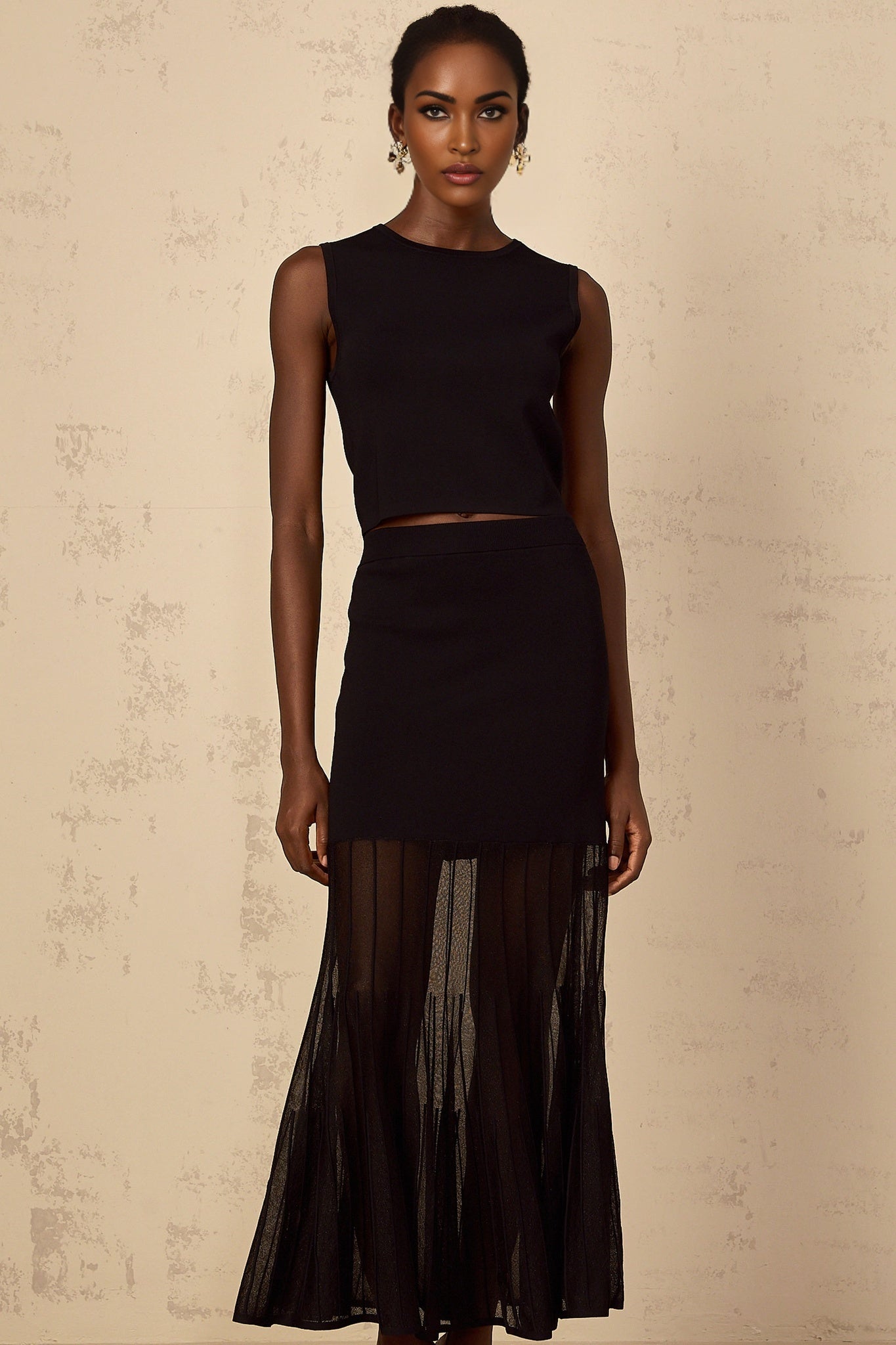 Woman wearing black knit twopiece outfit with panelled design top and matching bottoms