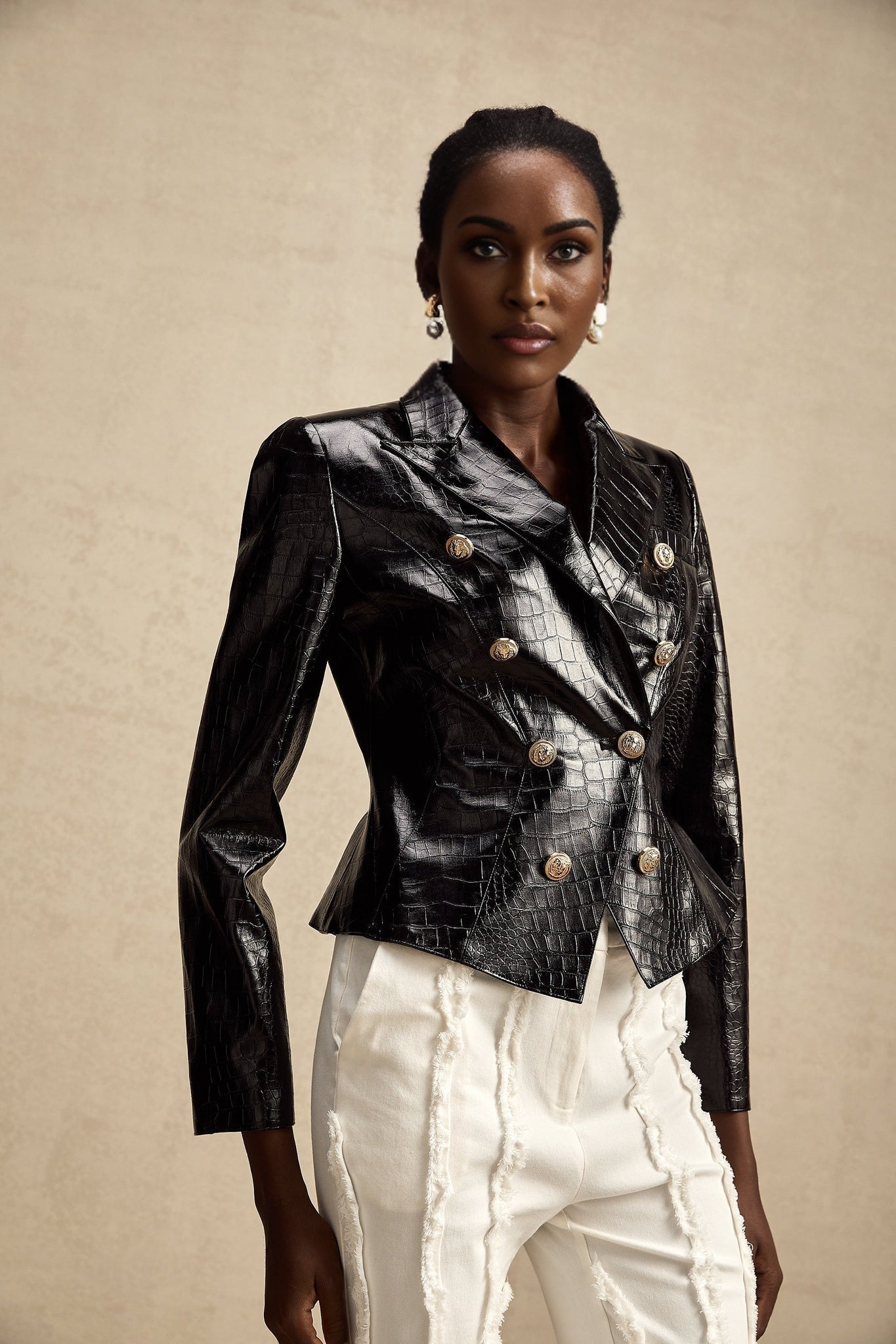 Woman wearing black leather jacket with cinched waist and zipper details