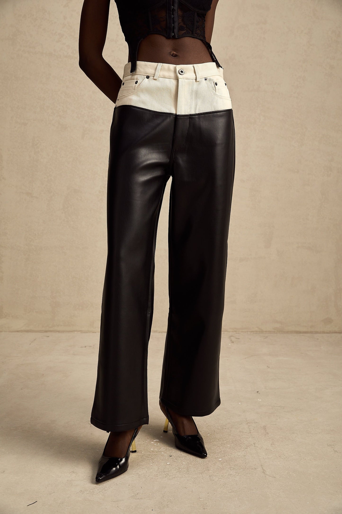 Woman wearing black leather trousers with white contrast panels on the sides