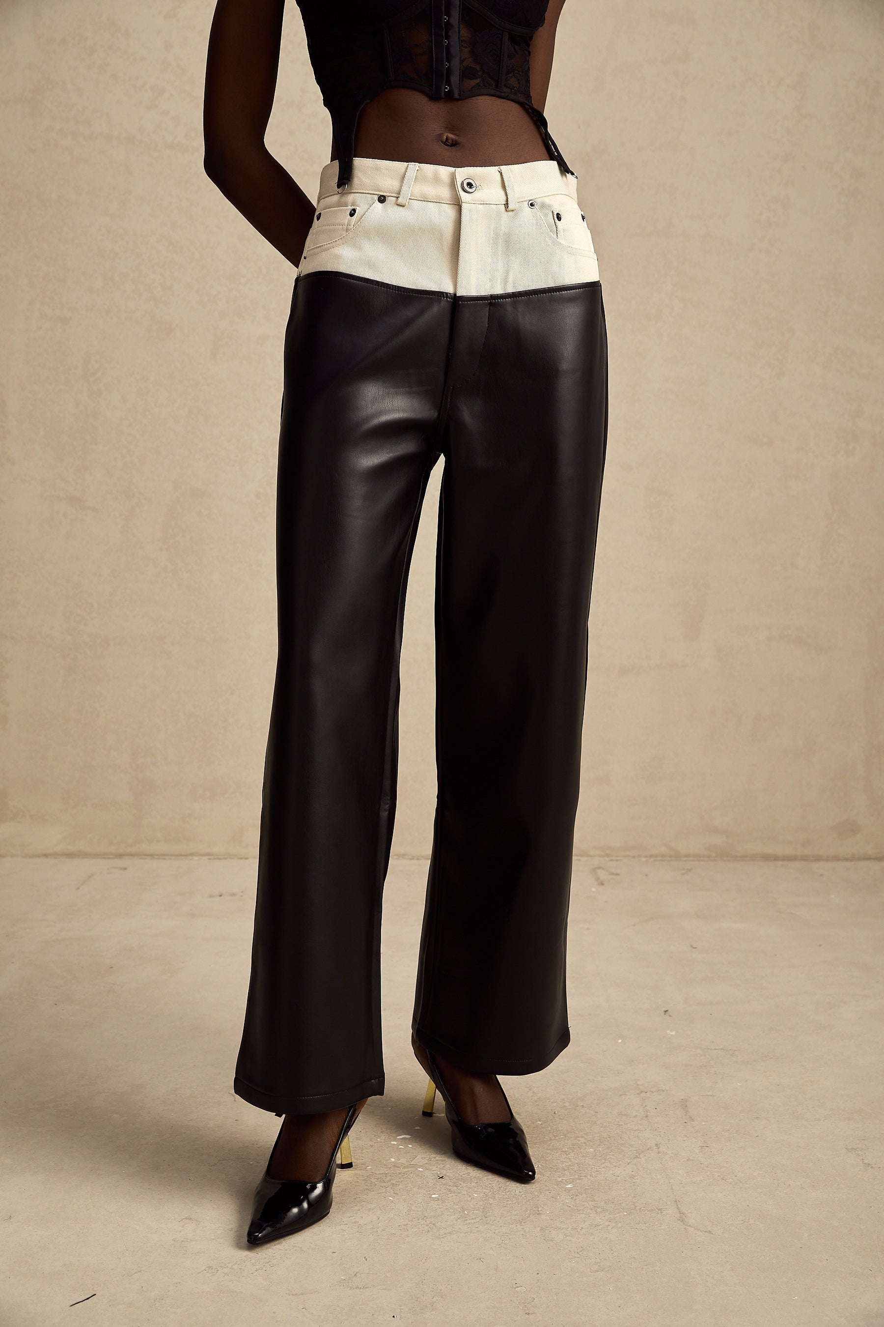 Woman wearing black leather trousers with white contrast panels on the sides