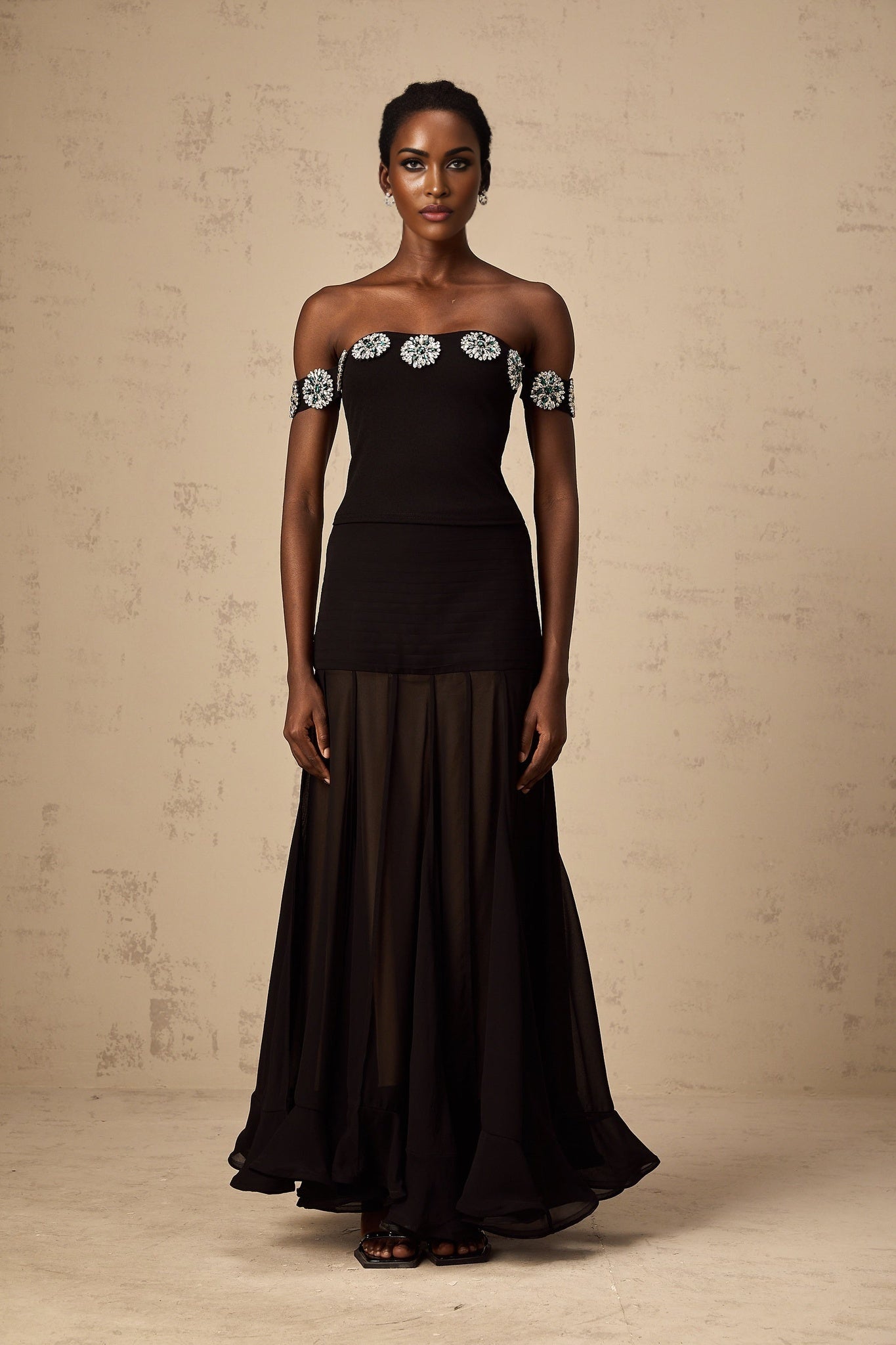 Woman wearing black off shoulder top with embellished details