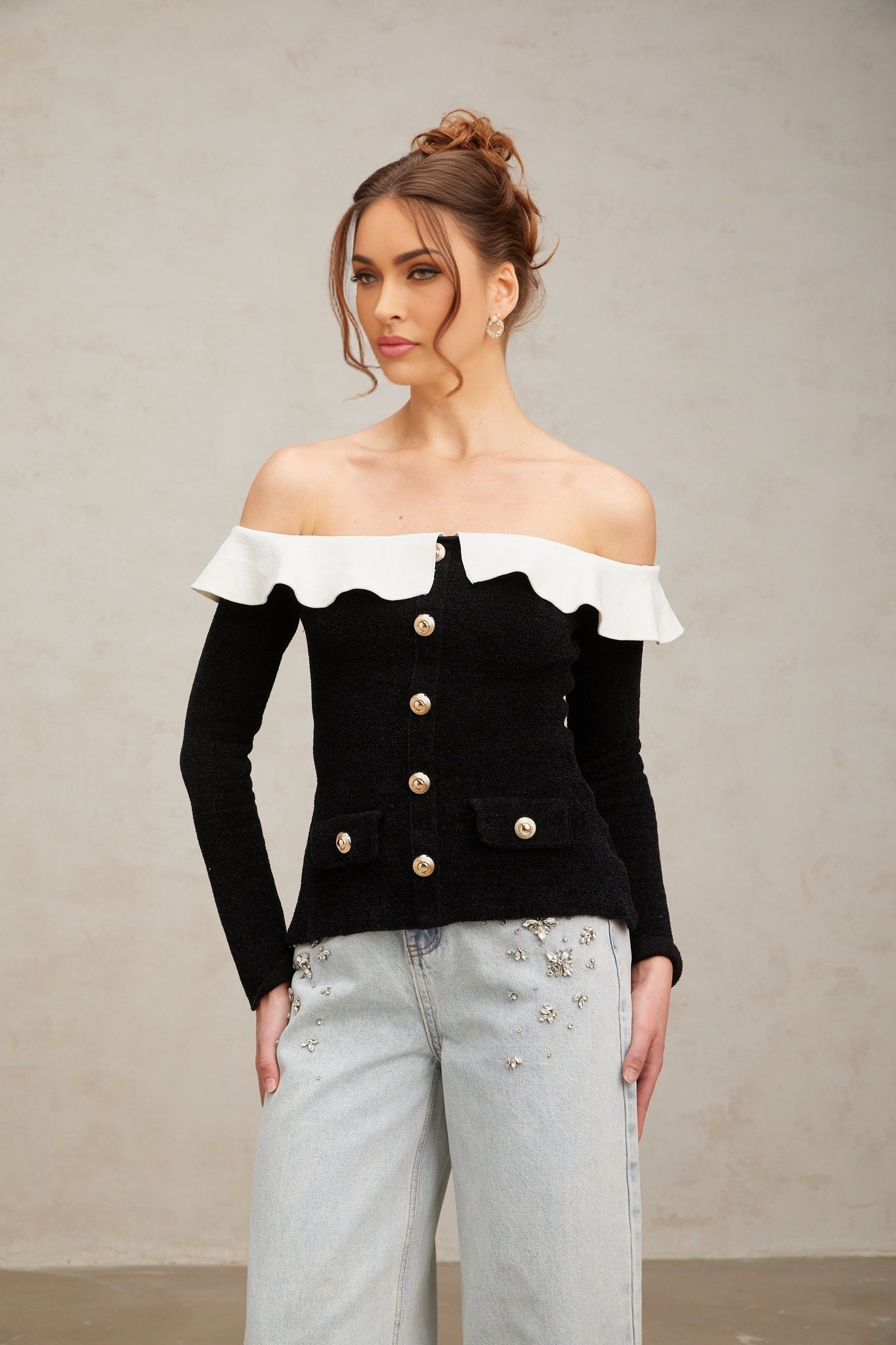 Woman wearing black off shoulder top with ruffled details