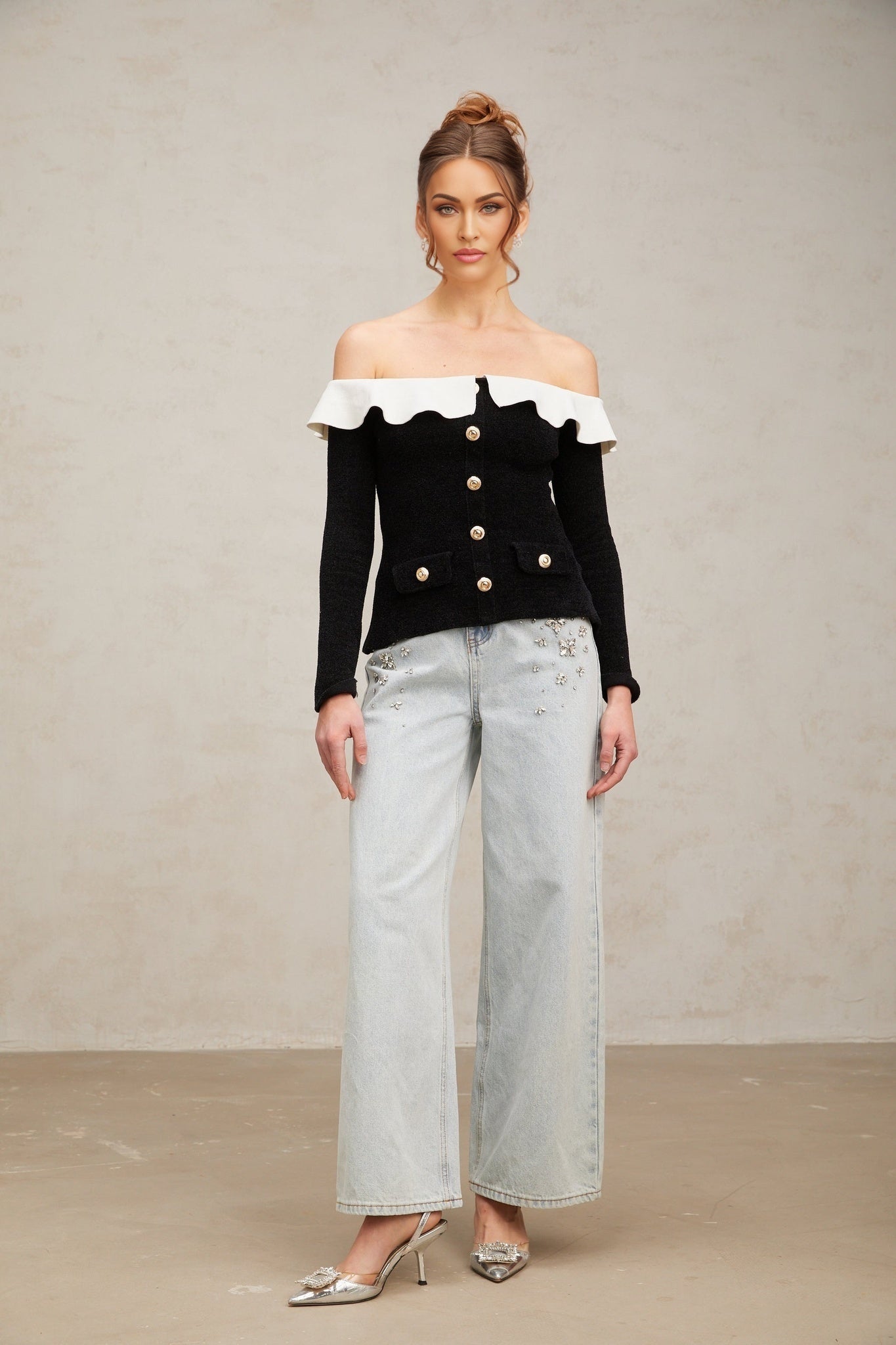 Woman wearing black off shoulder top with ruffled neckline