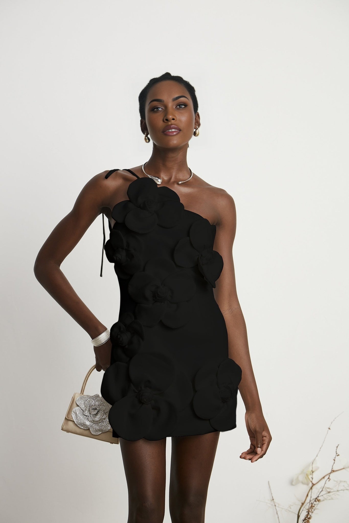 Woman wearing black offshoulder mini dress with floral pattern