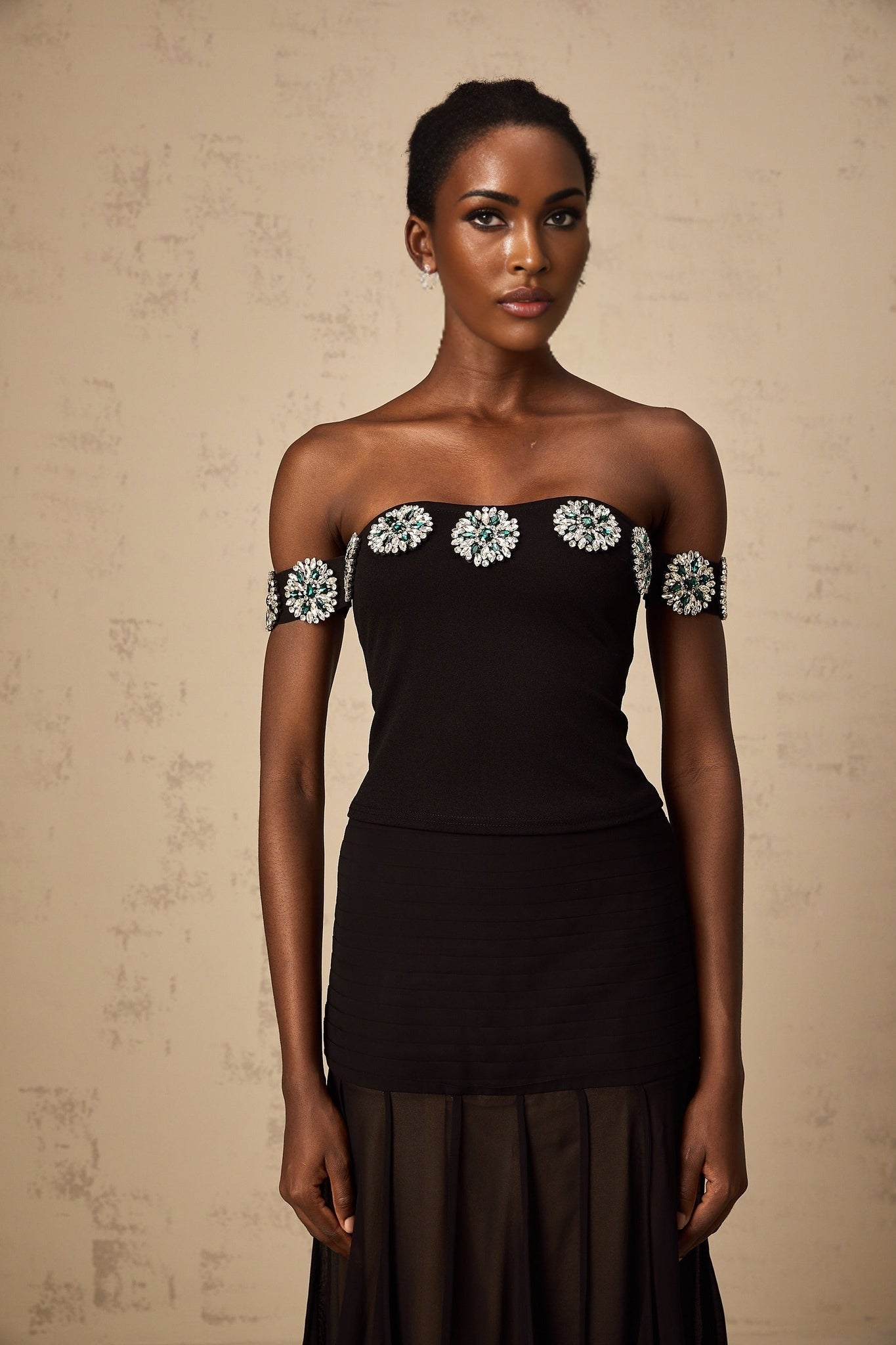 Woman wearing black offshoulder top with embellishments