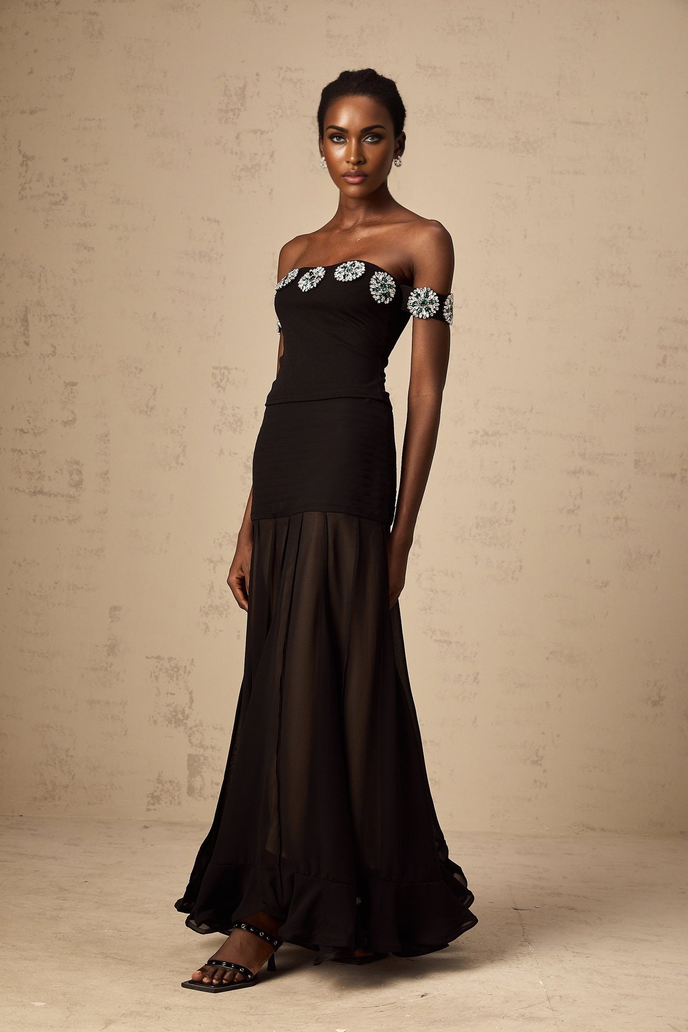 Woman wearing black offshoulder top with embellishments