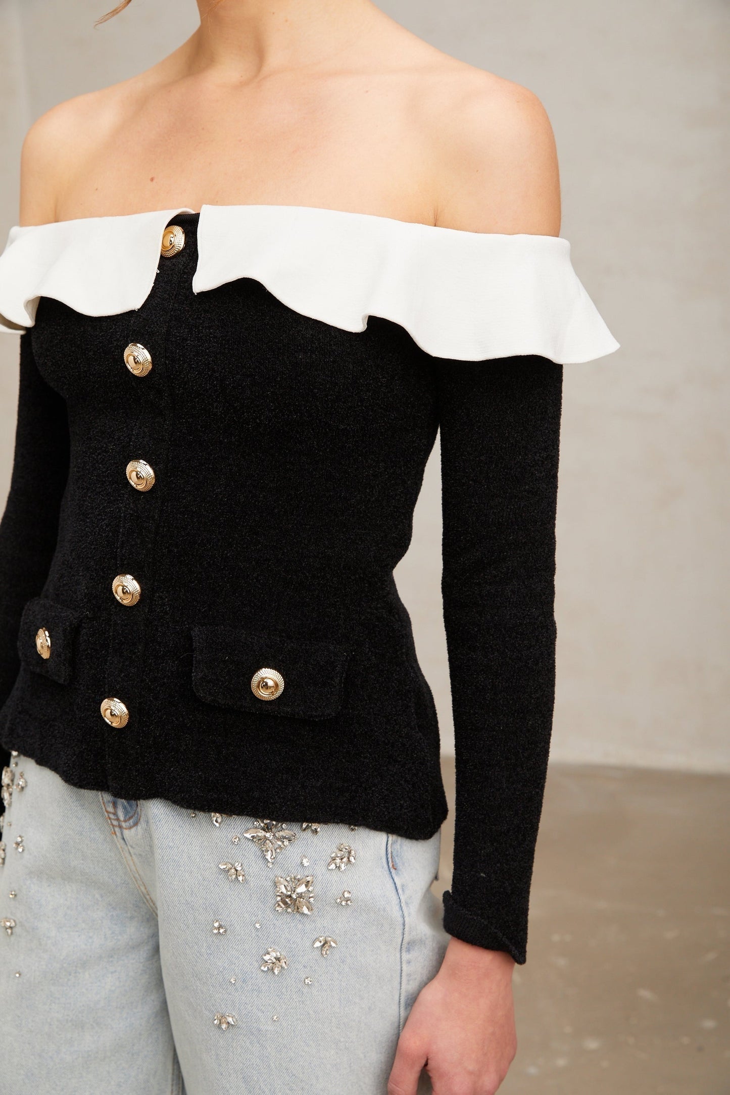 Woman wearing black offshoulder top with ruffle detail