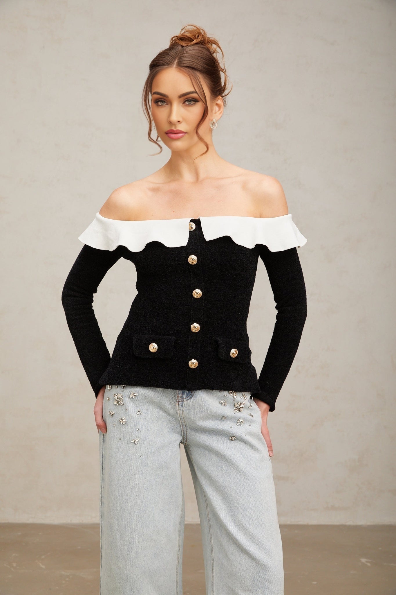 Woman wearing black offshoulder top with ruffled neckline