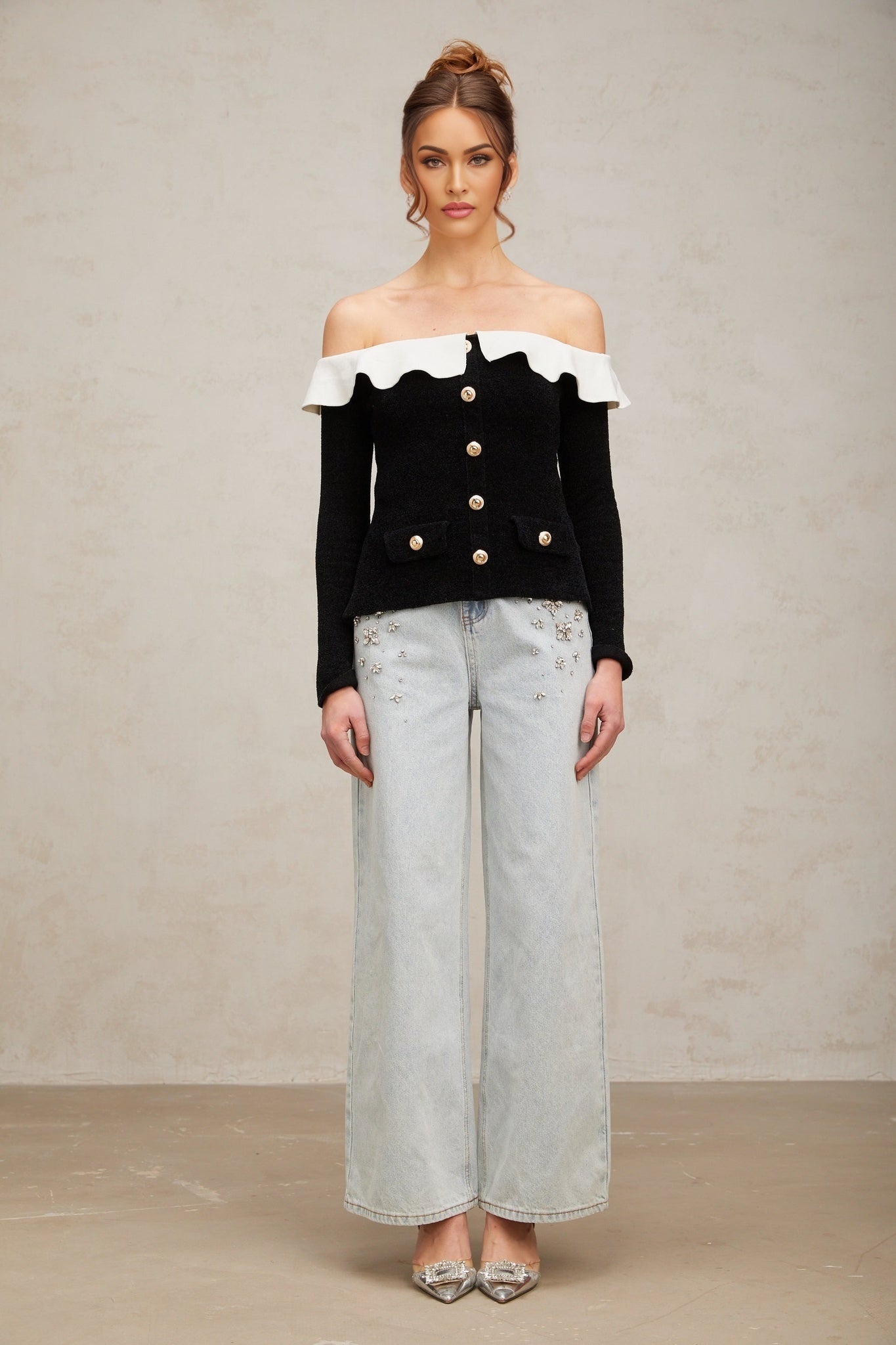 Woman wearing black offshoulder top with ruffled neckline