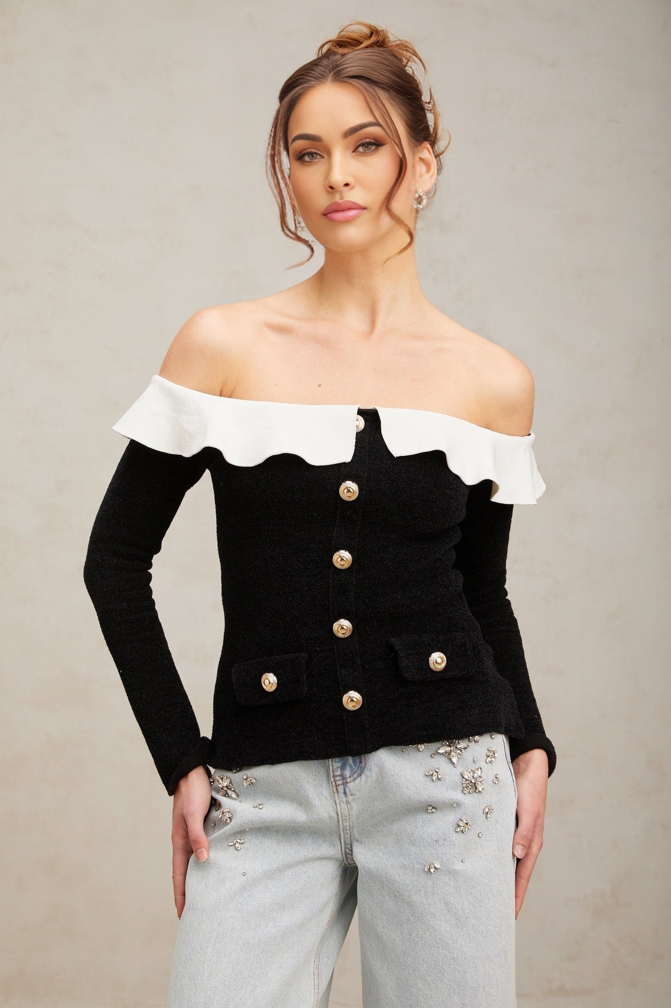 Woman wearing black offshoulder top with ruffled neckline